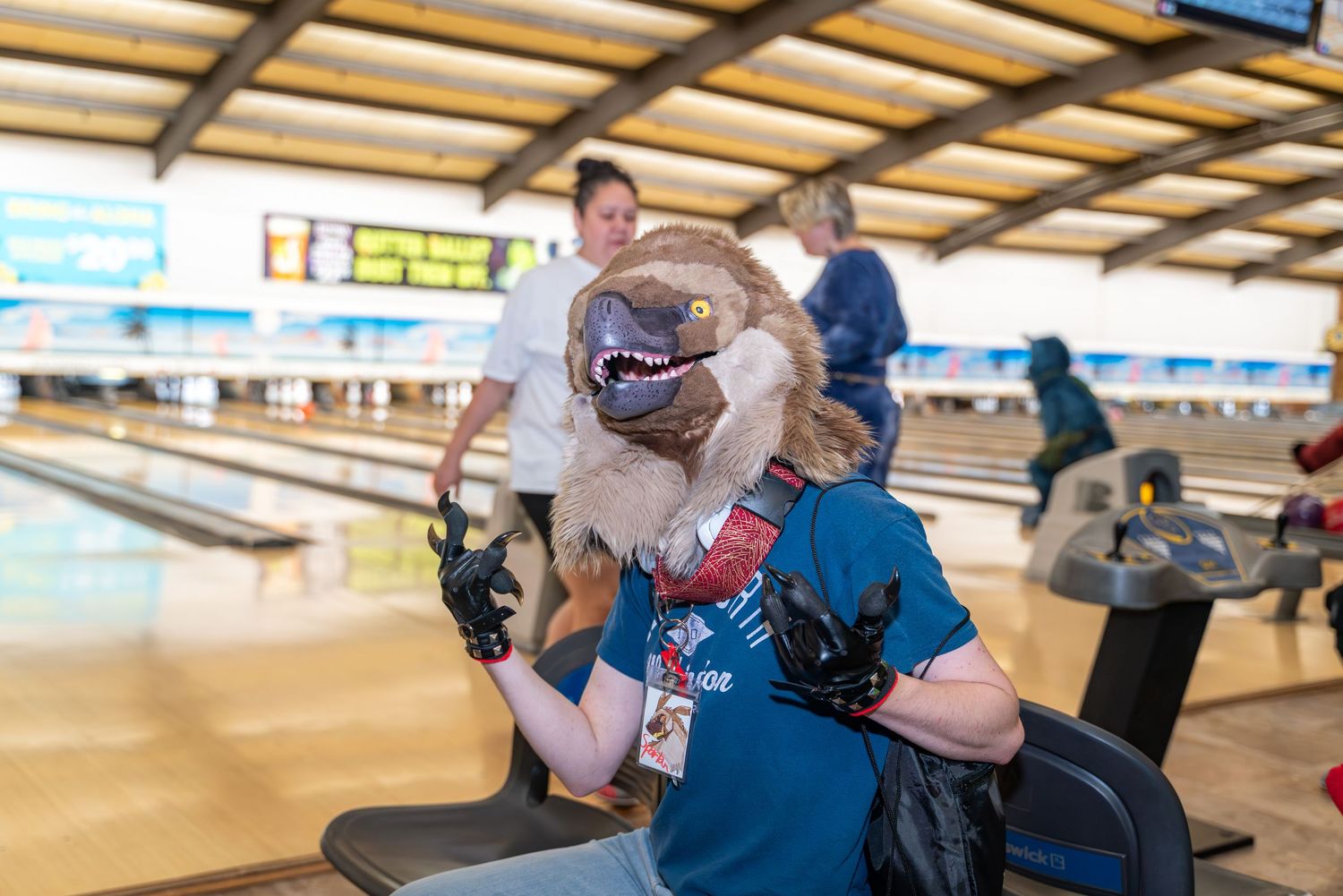 People bowling at a bowling alley showing multiple lanes with players in action.