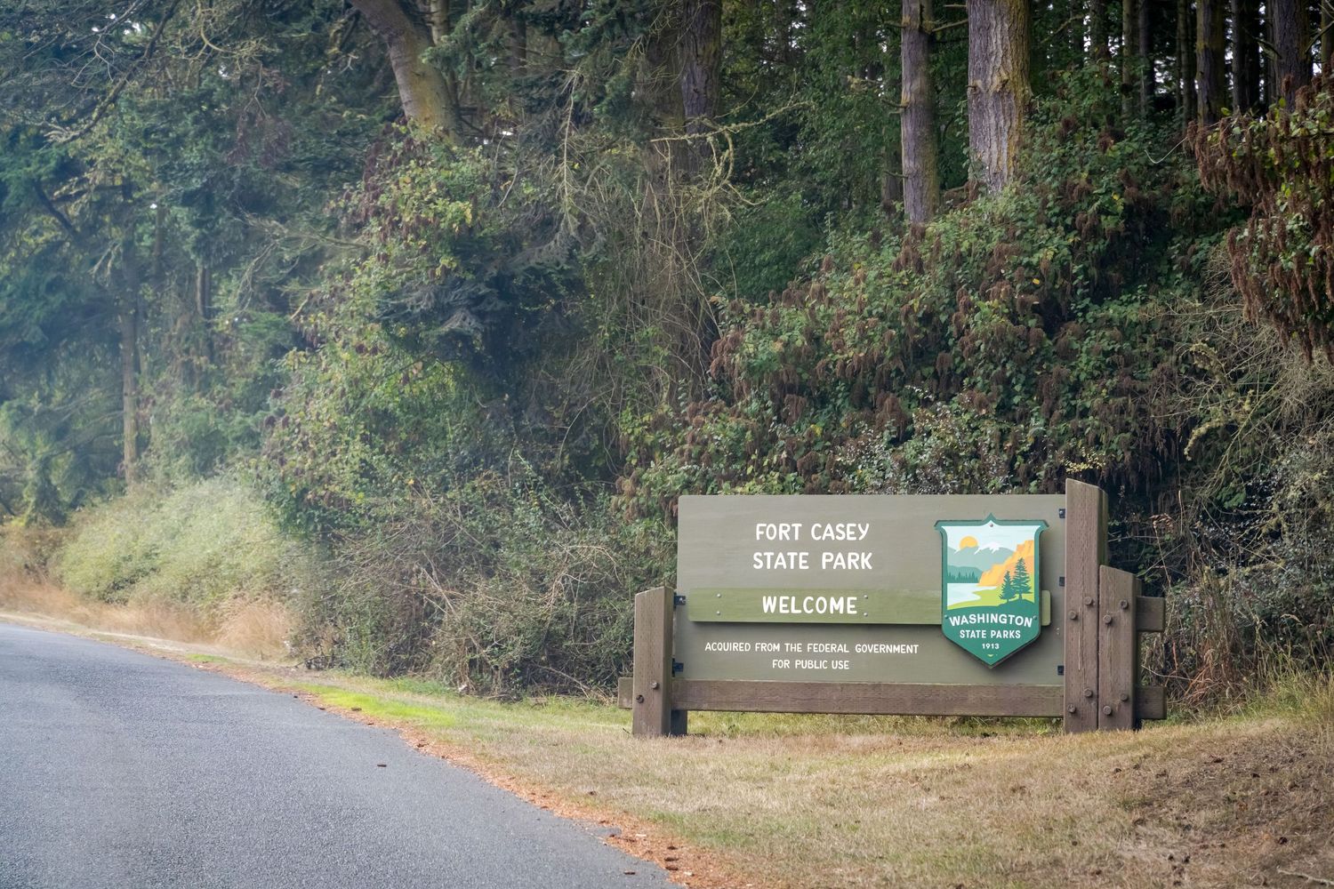 Wooded trail with interpretive signs and markers along a forest path.