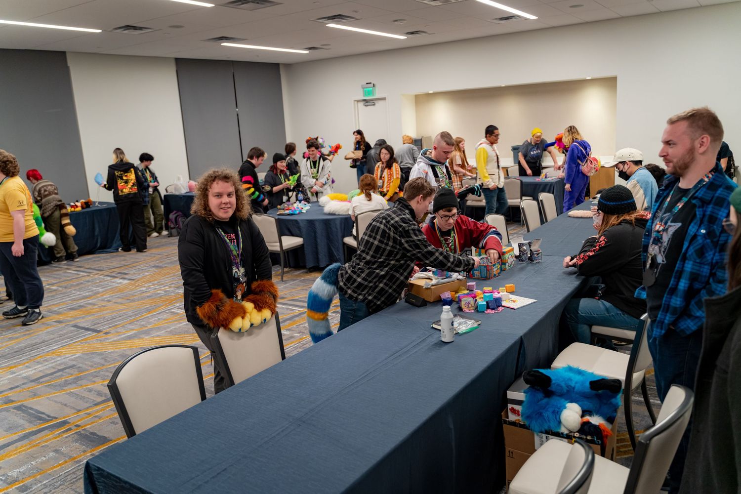 Gaming tournament venue with rows of players seated at tables in a brightly lit conference room.