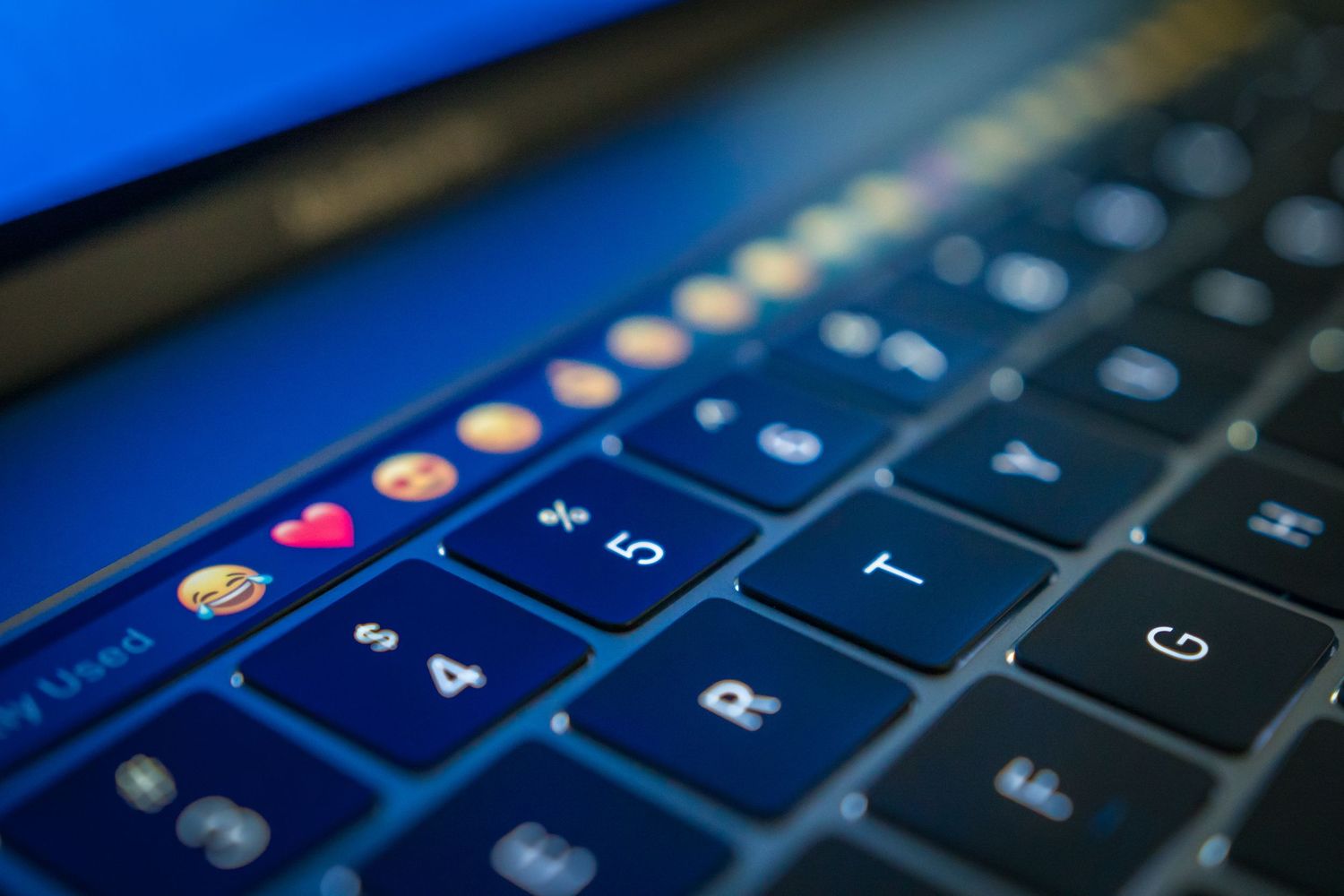 Close-up view of illuminated keyboard keys with blue backlighting on a laptop or desktop computer.