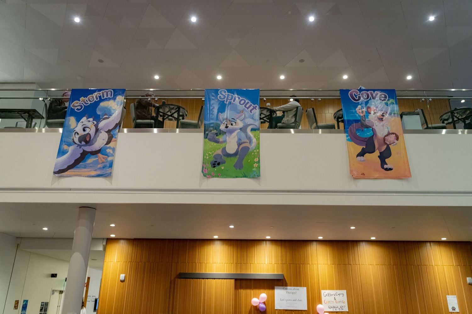 Modern retail interior with recessed lighting and colorful promotional banners displayed on walls.