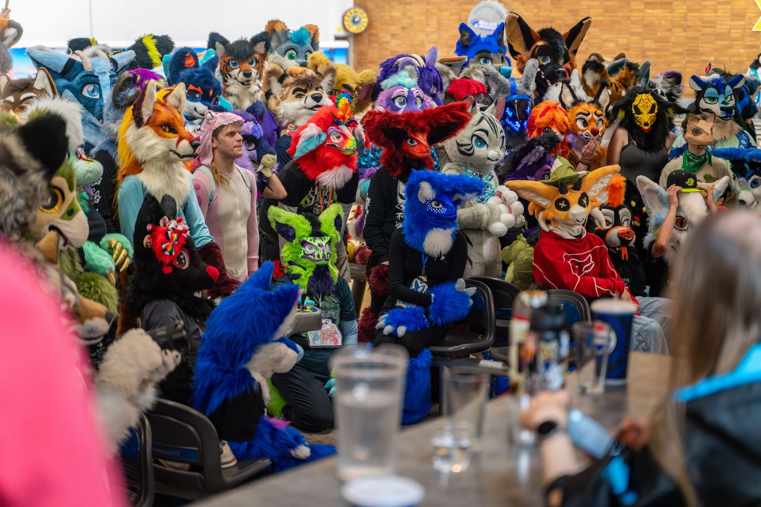 Costumed attendees in colorful fursuits gathered at a bowling event.