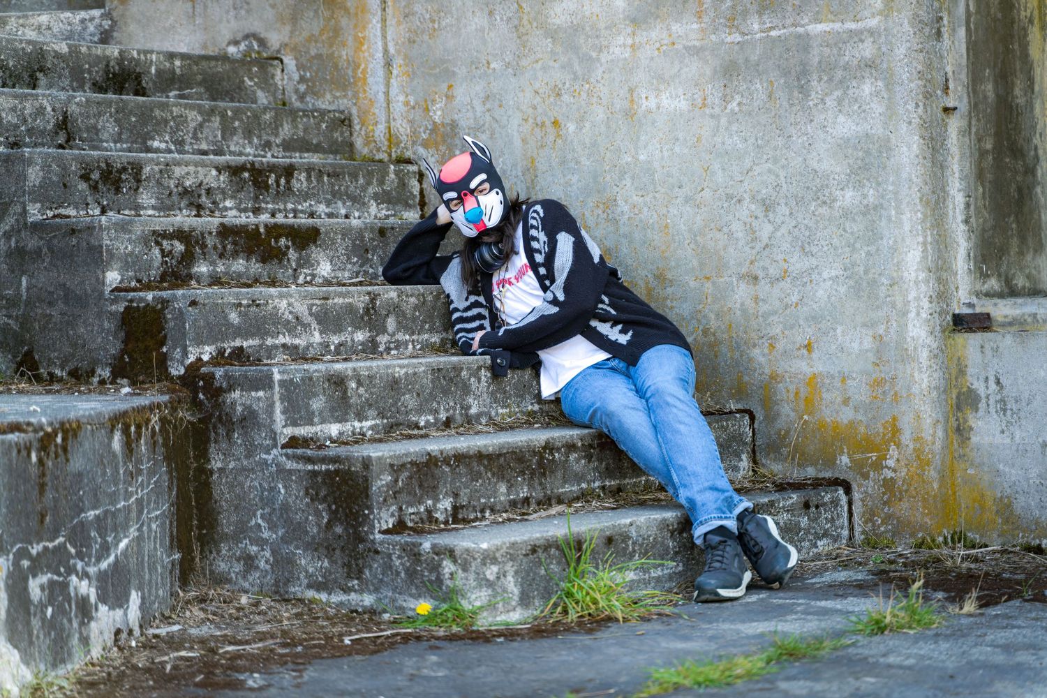 People in costumes rest along concrete steps of historic military fortification.