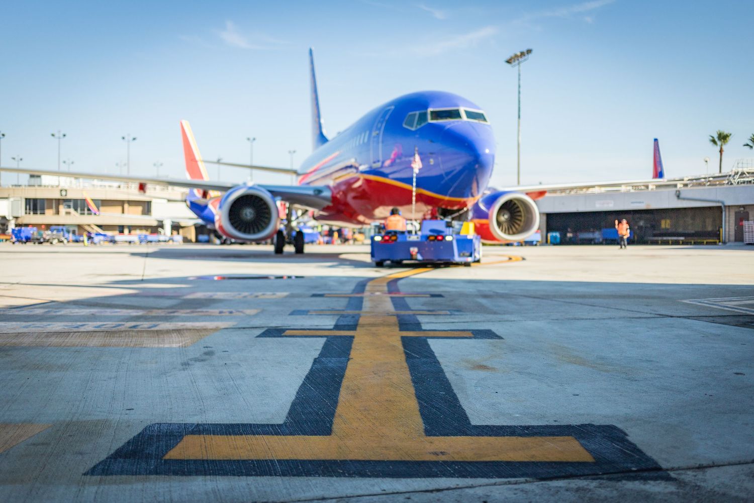 Commercial airplanes parked at airport gates with ground service equipment visible on tarmac.