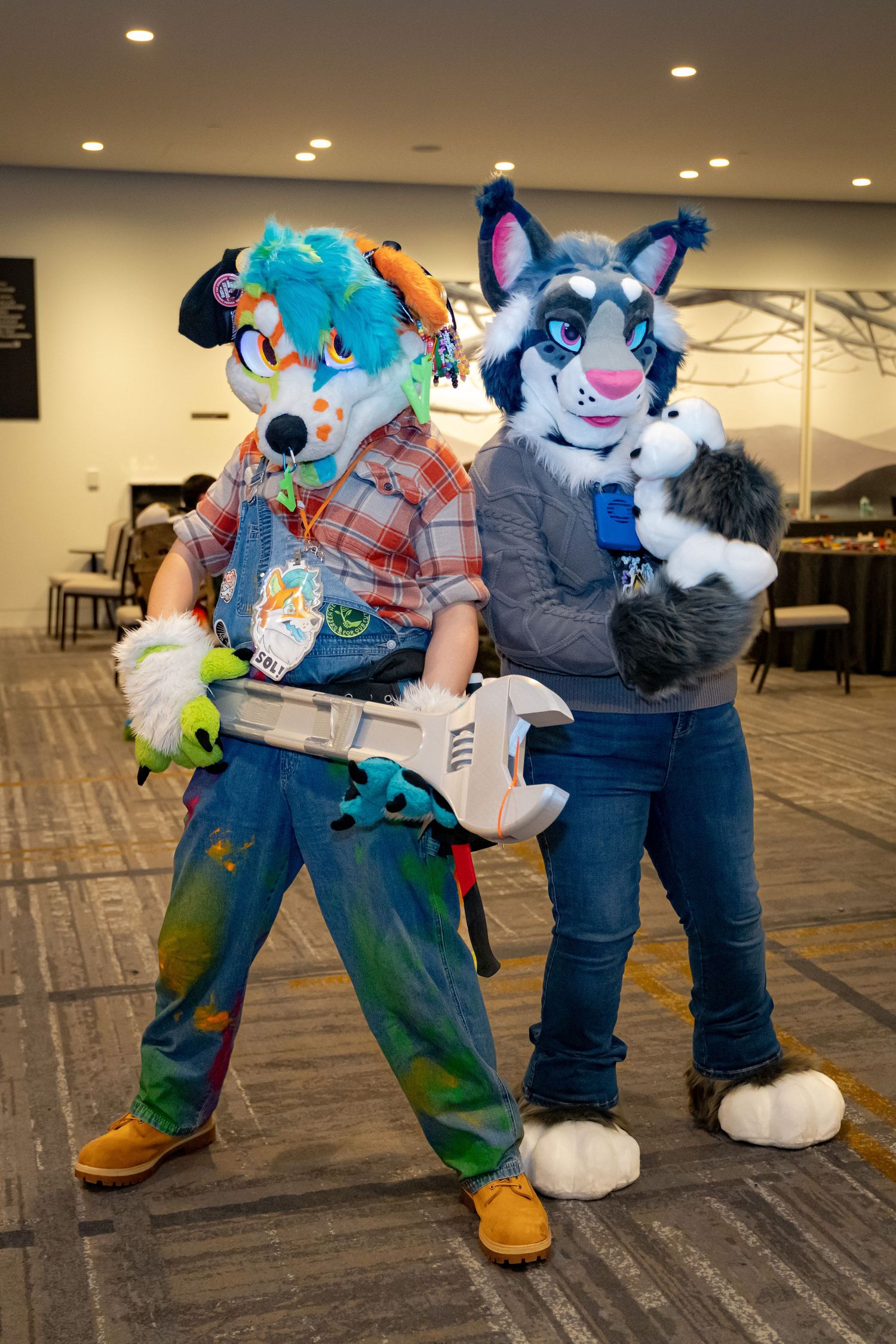 Several fursuit characters in colorful costumes posing together on a carpeted floor at an indoor event.
