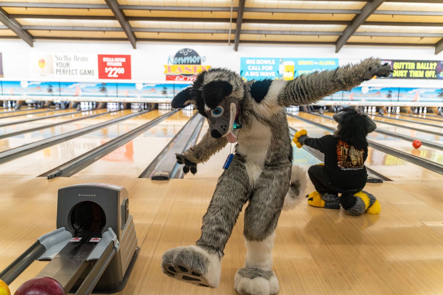 A fursuited bowler leans forward dramatically while bowling.