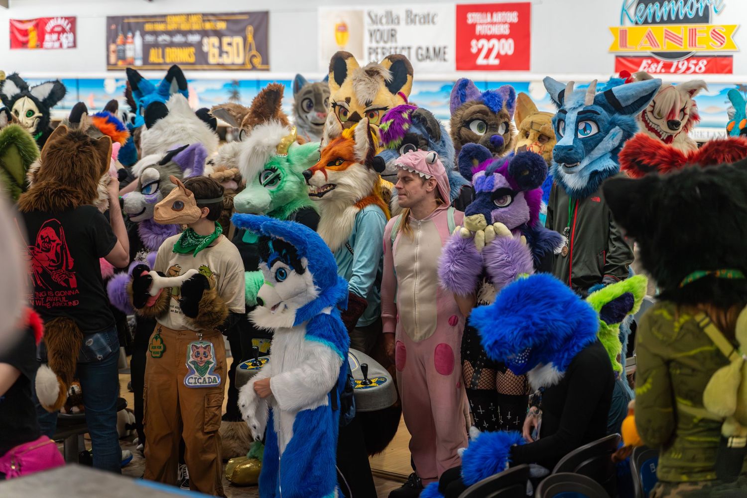 Colorful crowd of fursuit characters gathered at an indoor event.