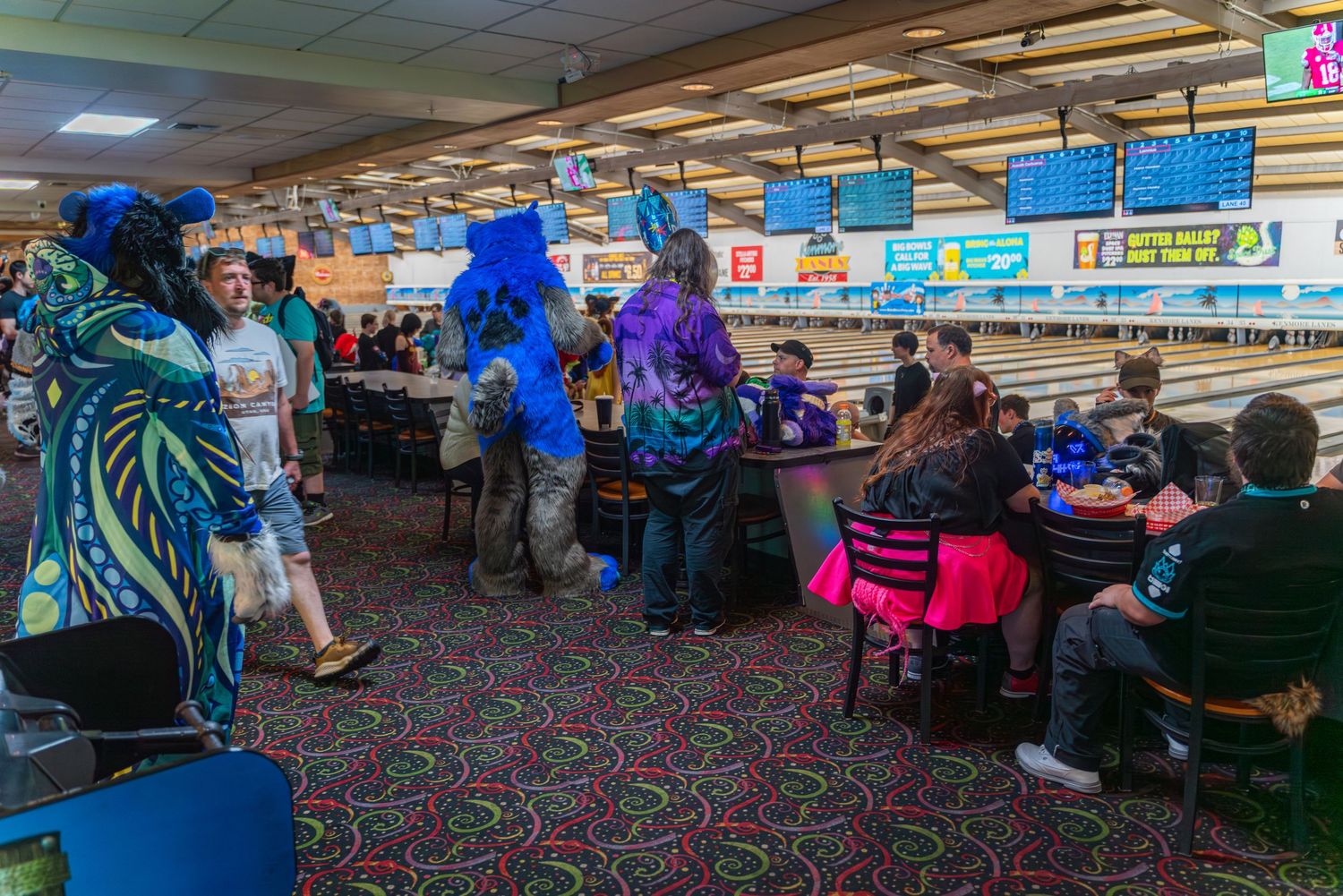Panoramic view of bowling alley showing multiple lanes and electronic scoring displays.