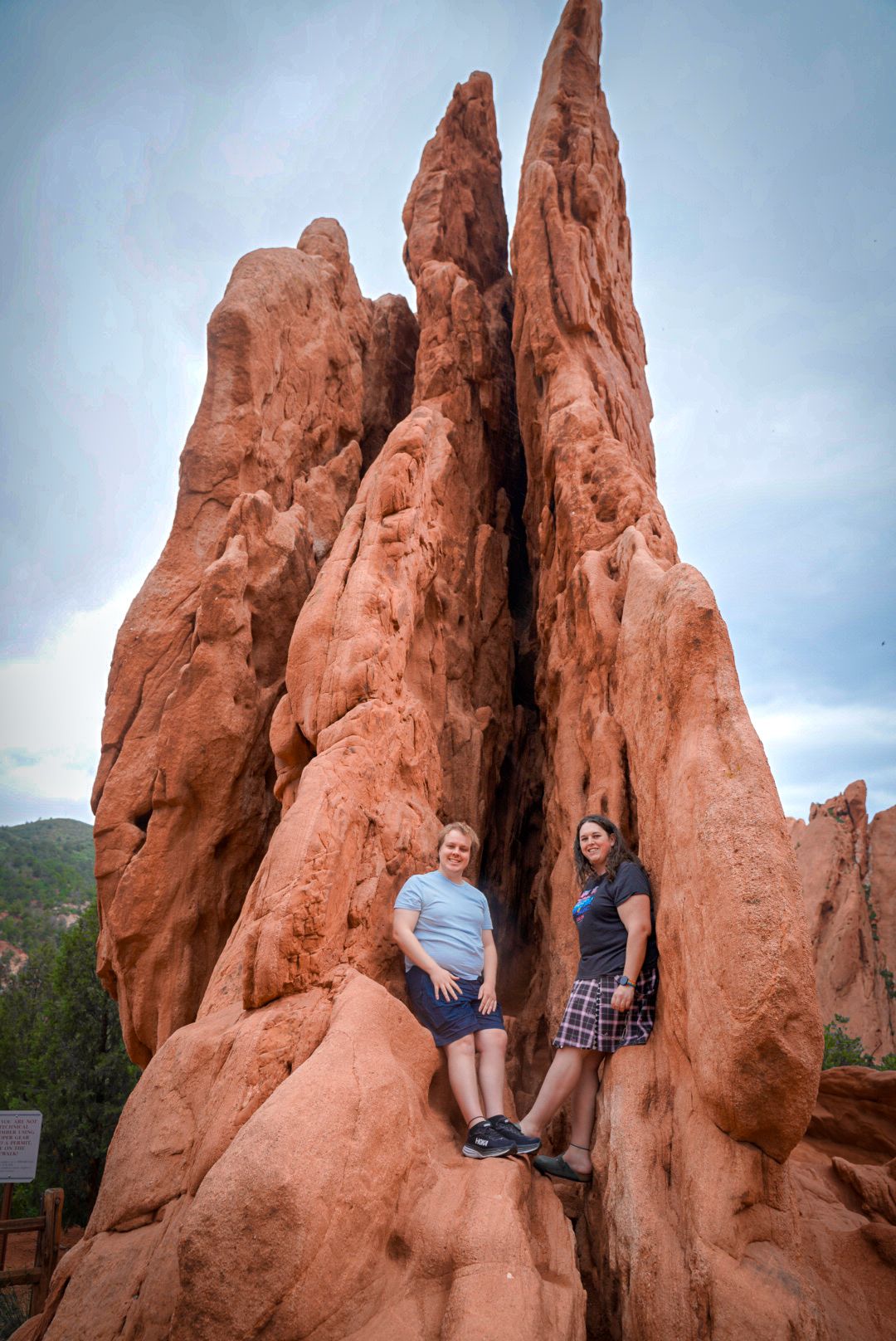 Adventure seekers pose on dramatic red rock formations at Garden of the Gods.