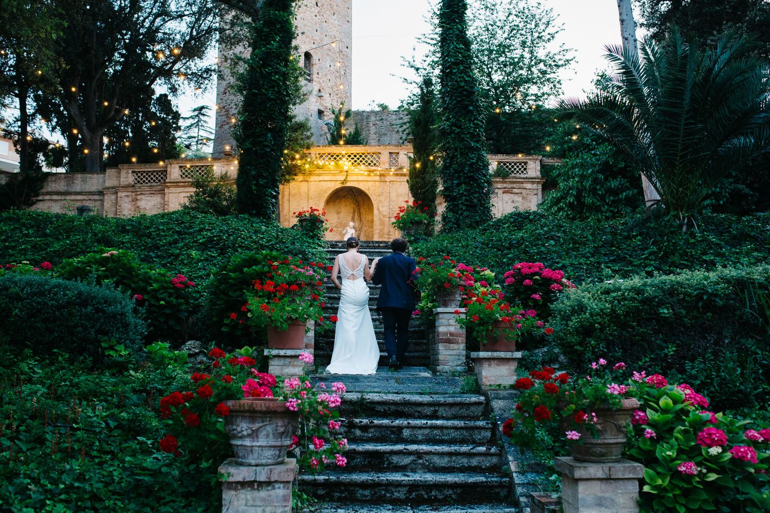 Bride and groom walking through a historic village in Le Marche during their destination wedding