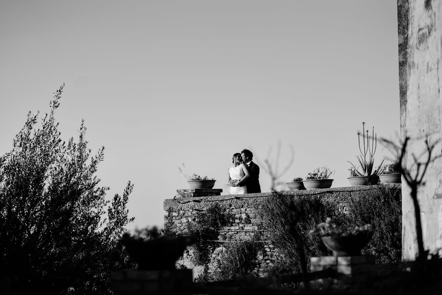 Bride and groom sharing a quiet moment in a romantic courtyard in the countryside of Le Marche, Italy