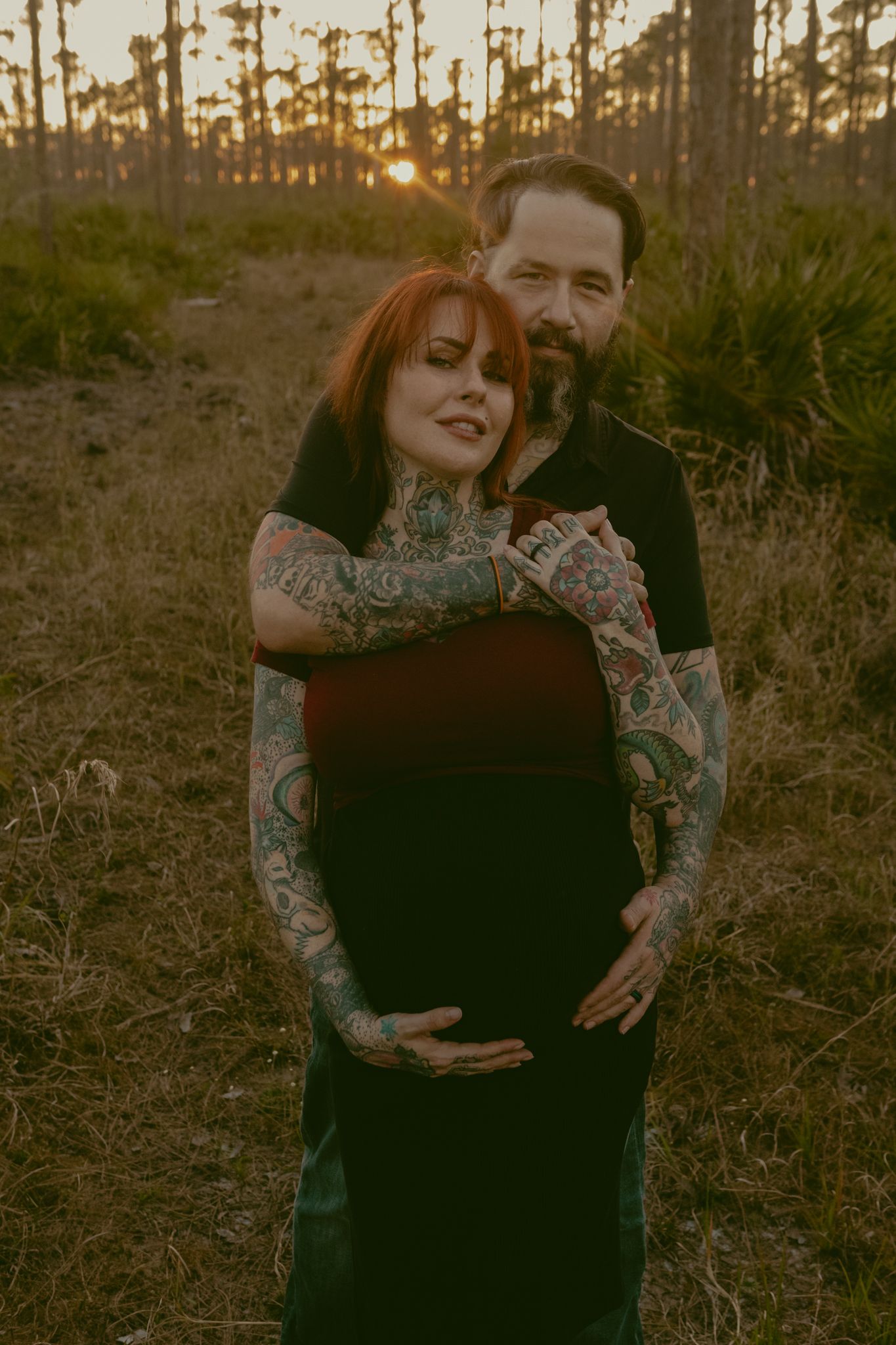 Tattooed couple poses in the Myakka State Park in Venice Florida. The woman of the couple is pregnant.