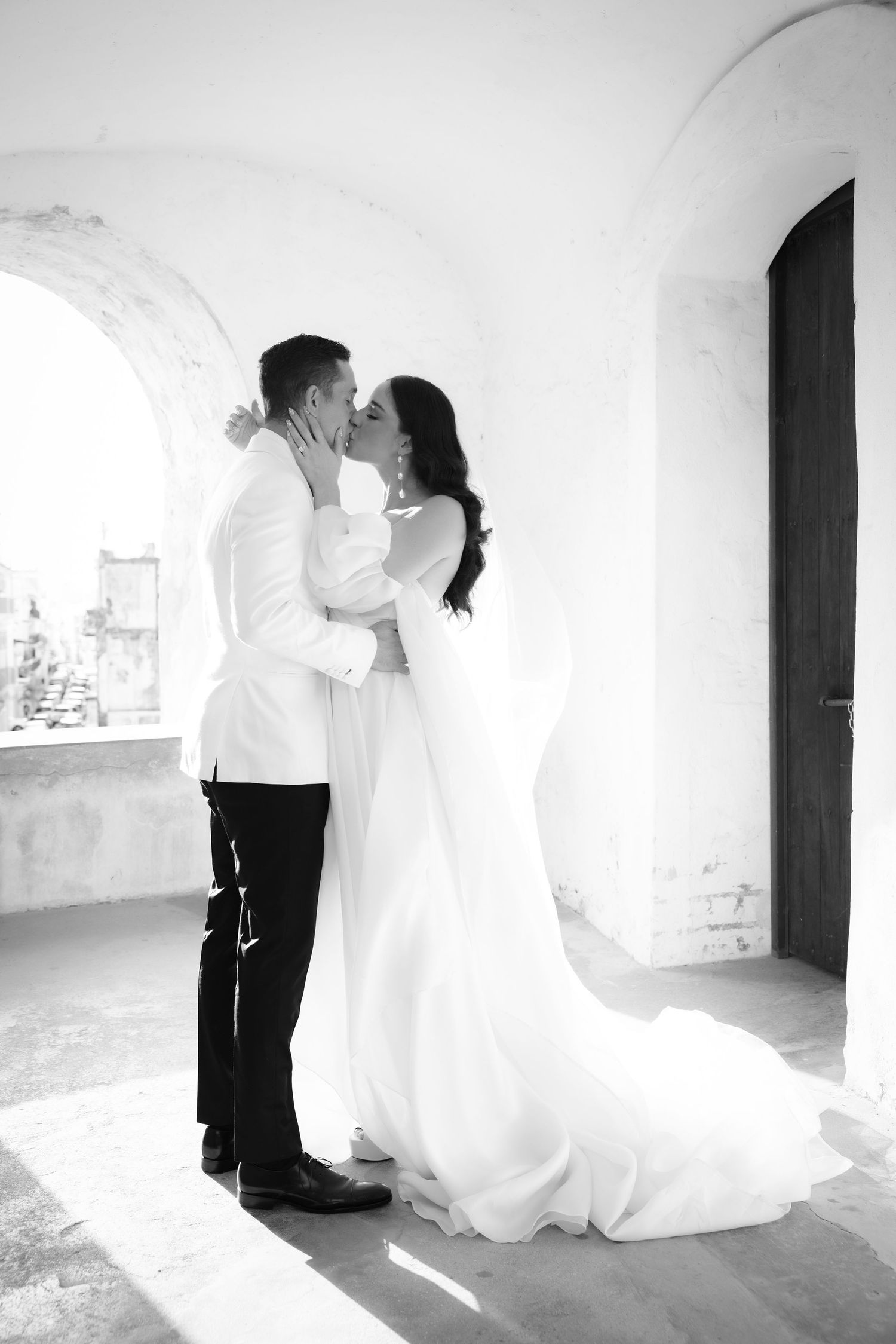 Romantic black and white wedding portraits taken in a historic stone hallway.