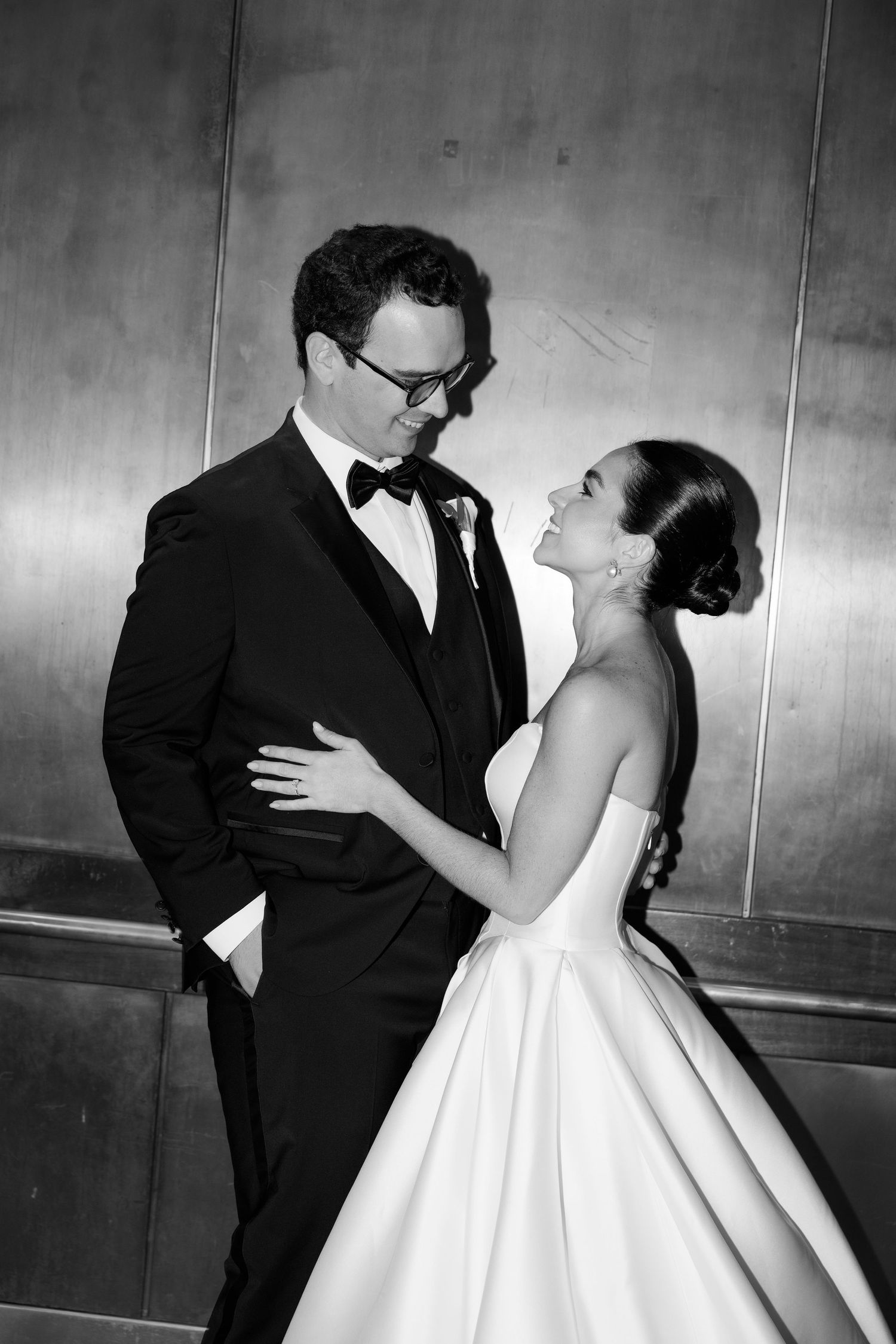 Black and white wedding photos showing romantic moments between newlyweds against a minimalist background.