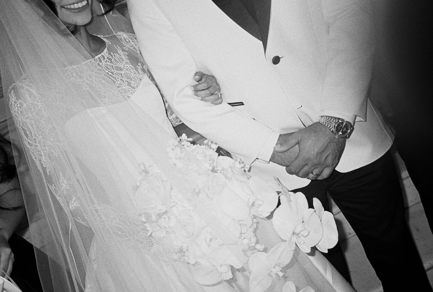 Black and white photo of a bride and groom cutting their wedding cake together.