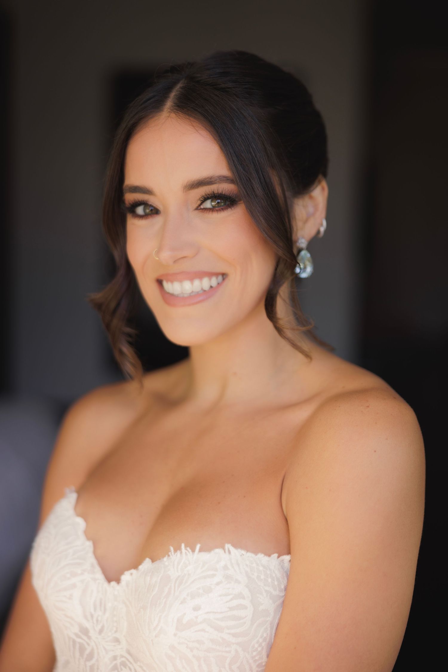 Close-up portrait shots of a bride in a white lace wedding dress with elegant hair and makeup.