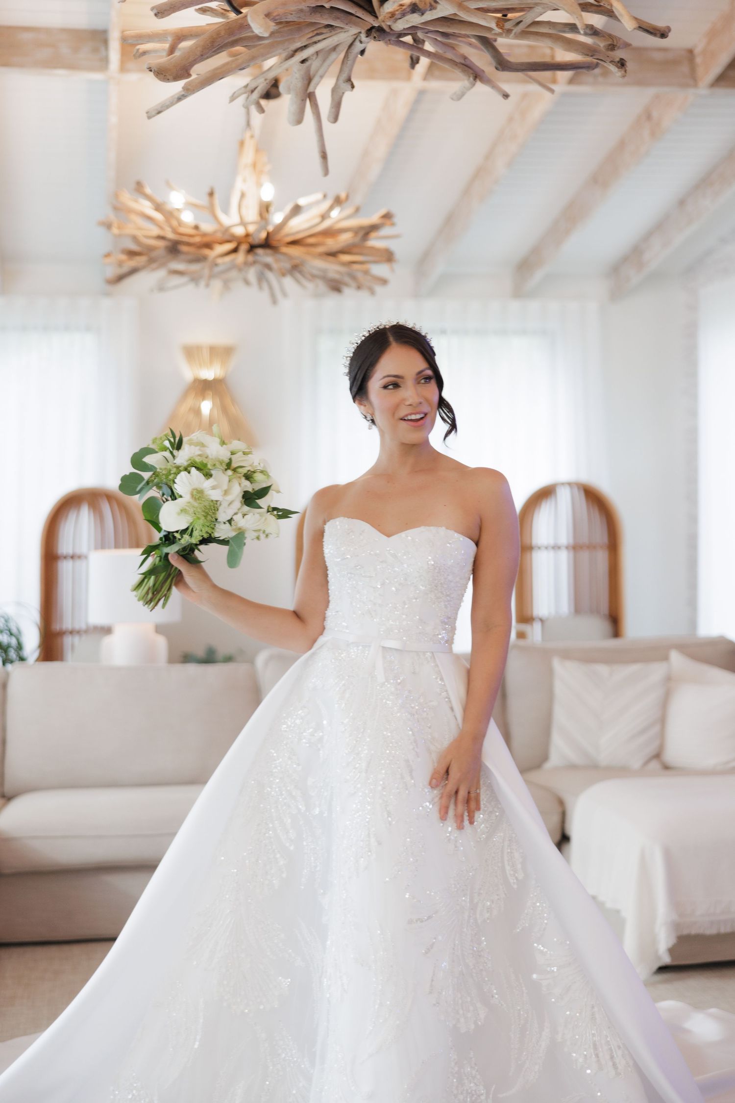 A strapless white wedding gown with floral details and a sweetheart neckline in a bright modern setting.