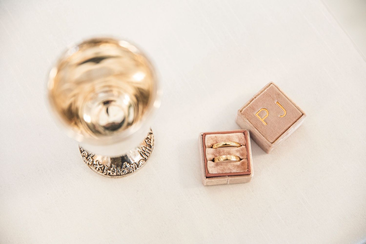 Two rose gold jewelry pieces including a band and decorative cubes displayed on white surface.