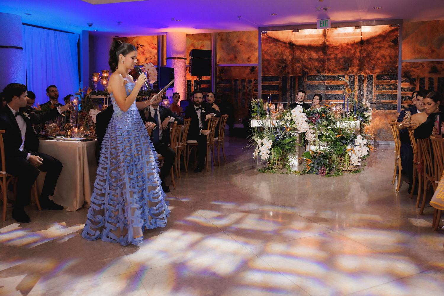 Wedding reception dance floor illuminated with blue and amber lighting creating a romantic atmosphere.