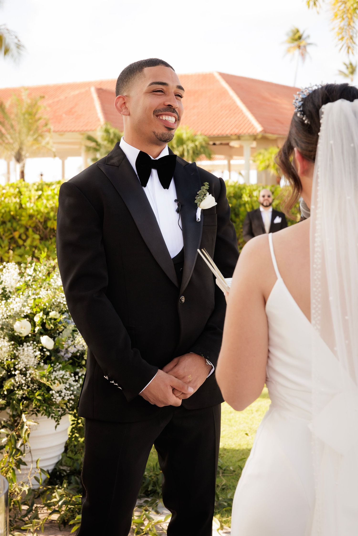 The bride and groom share a joyful moment together during an outdoor wedding ceremony.