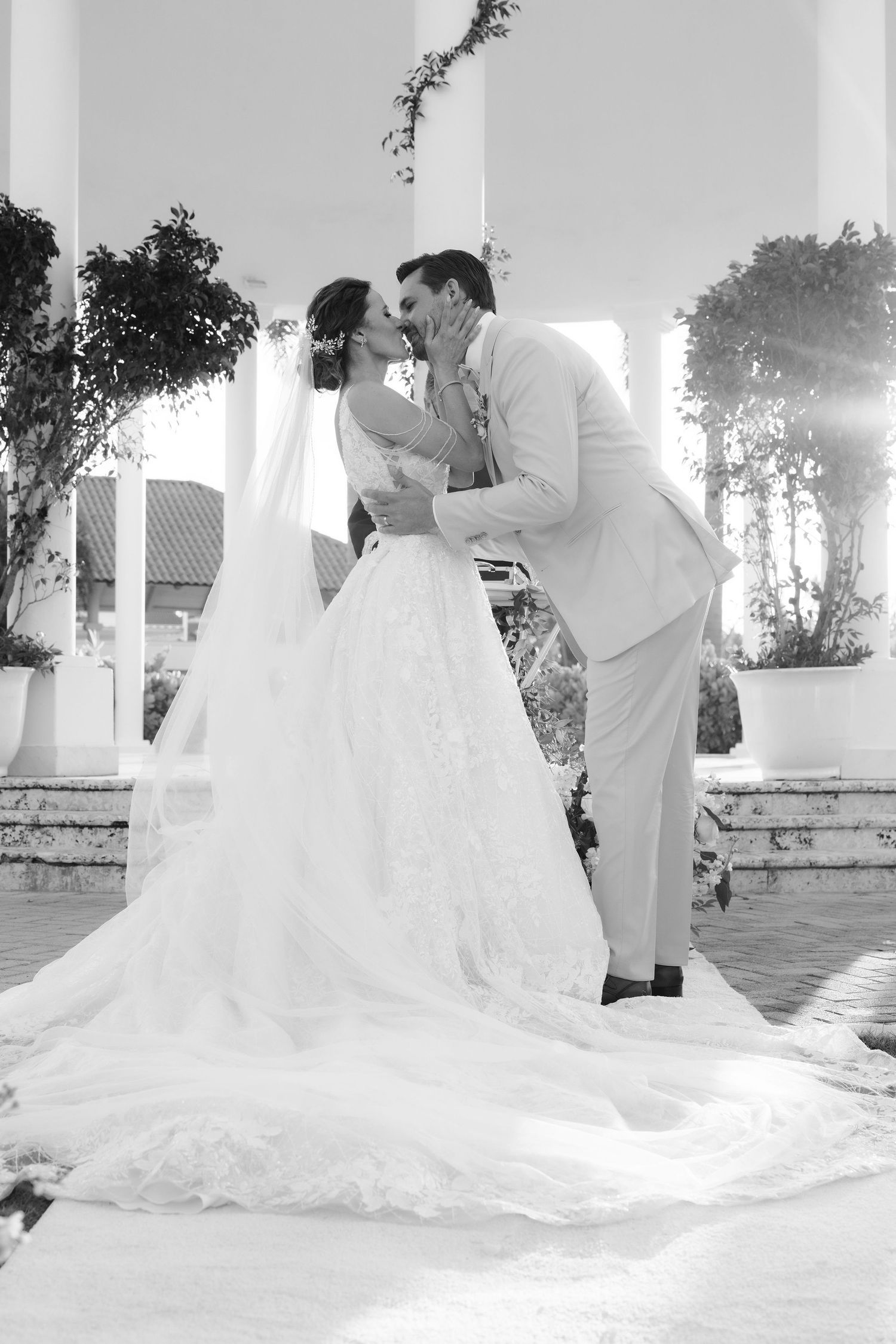 Black and white romantic wedding photos showcase a bride in a flowing gown with dramatic cathedral-length train.