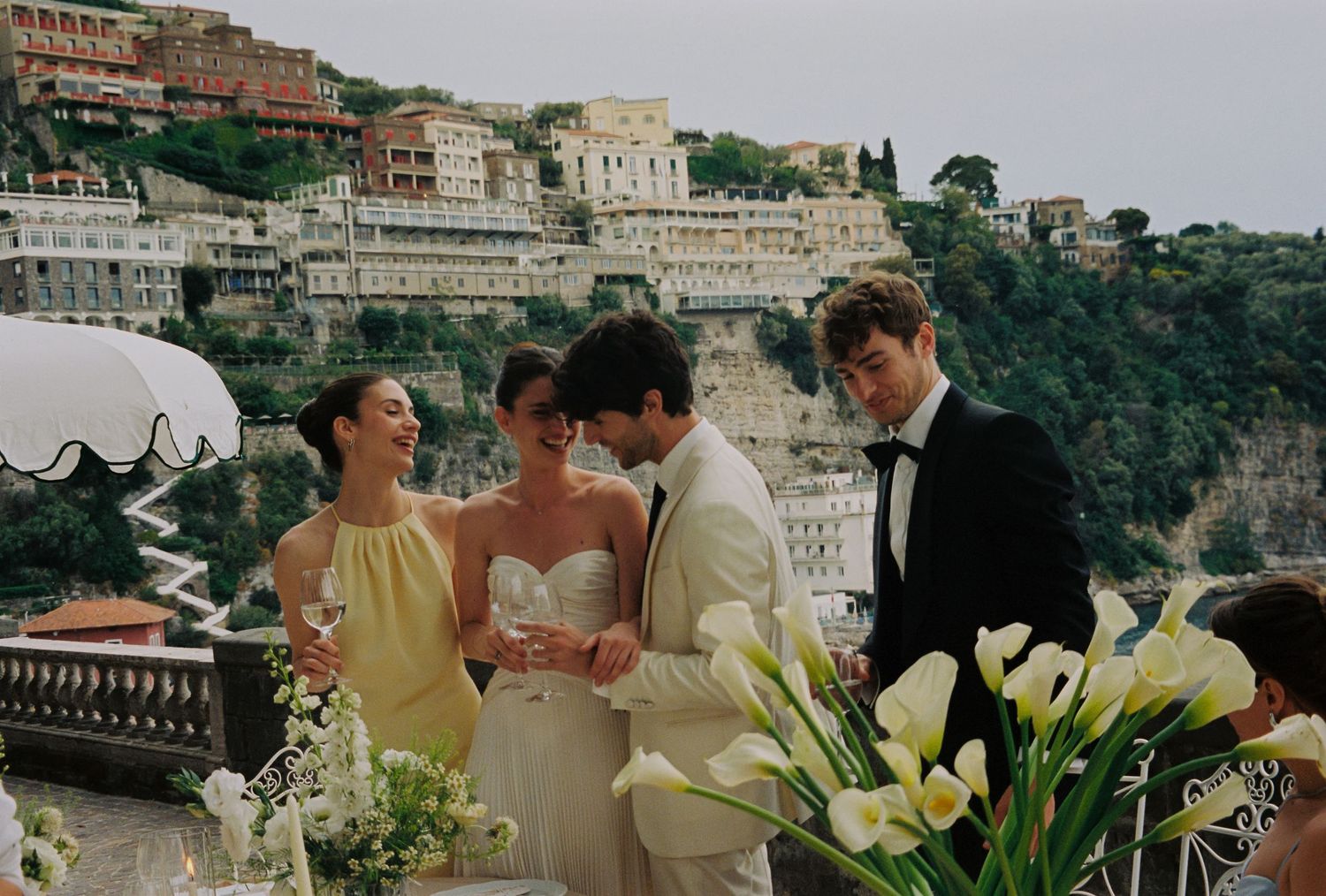 Elegant outdoor wedding ceremony in Positano, Italy, with bride in white gown and guests in formal attire.