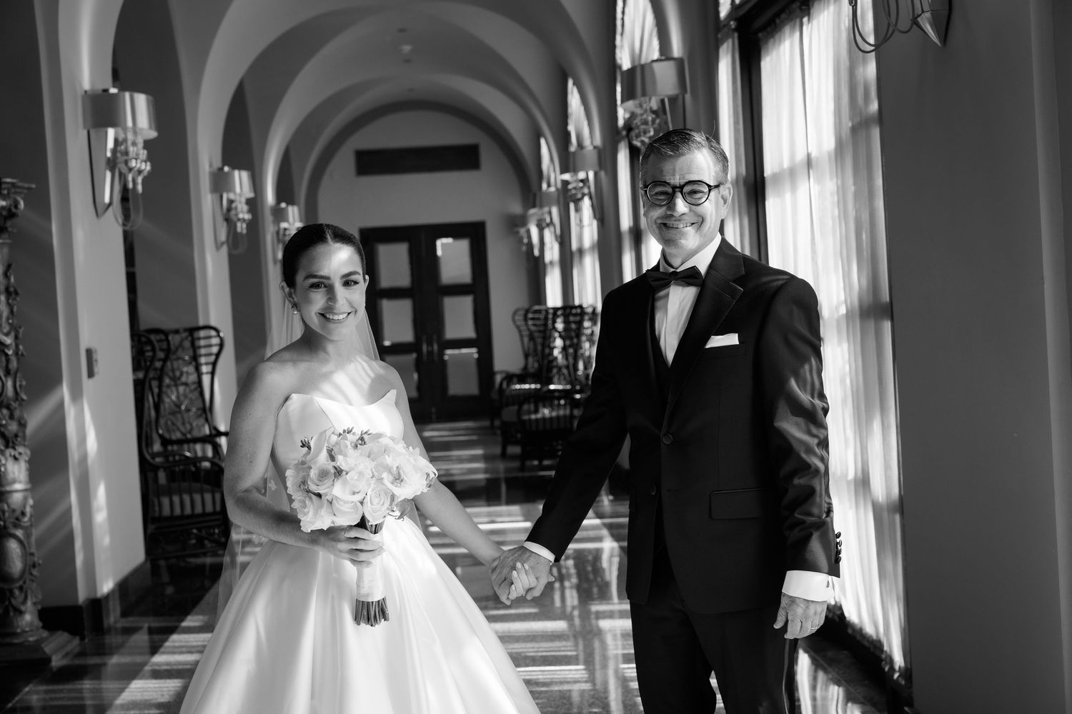 Black and white wedding photos displayed in a collage showing intimate moments in an elegant venue hallway.