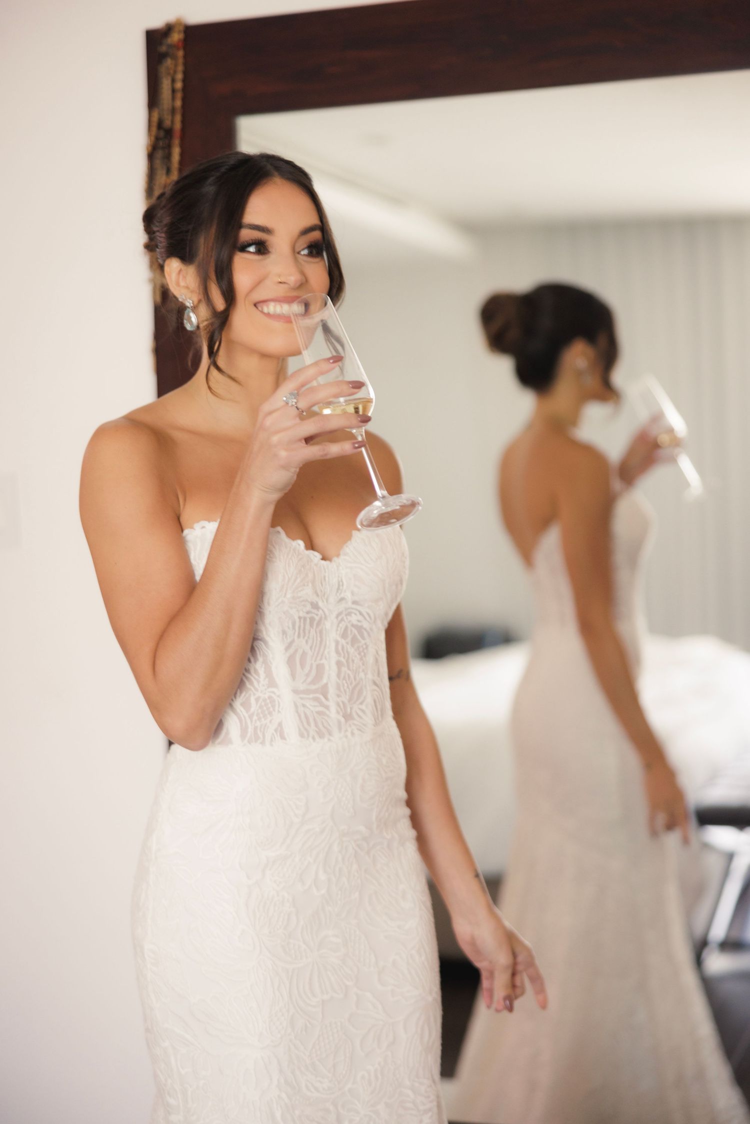 Elegant white lace wedding dress reflecting in a mirror during pre-wedding preparations.