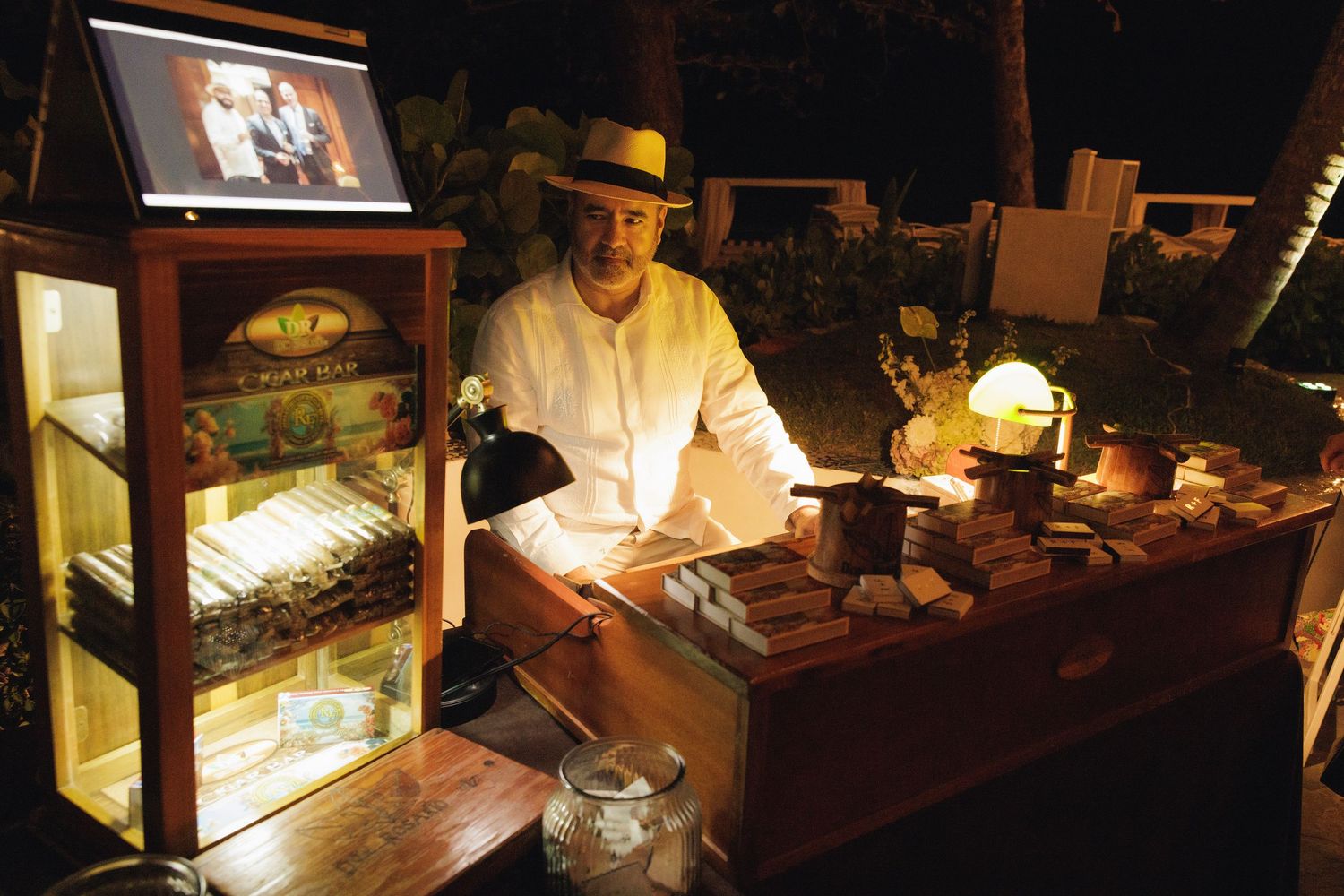 Birds, cameras and other vintage antique items displayed in illuminated glass cases with collector examining items.