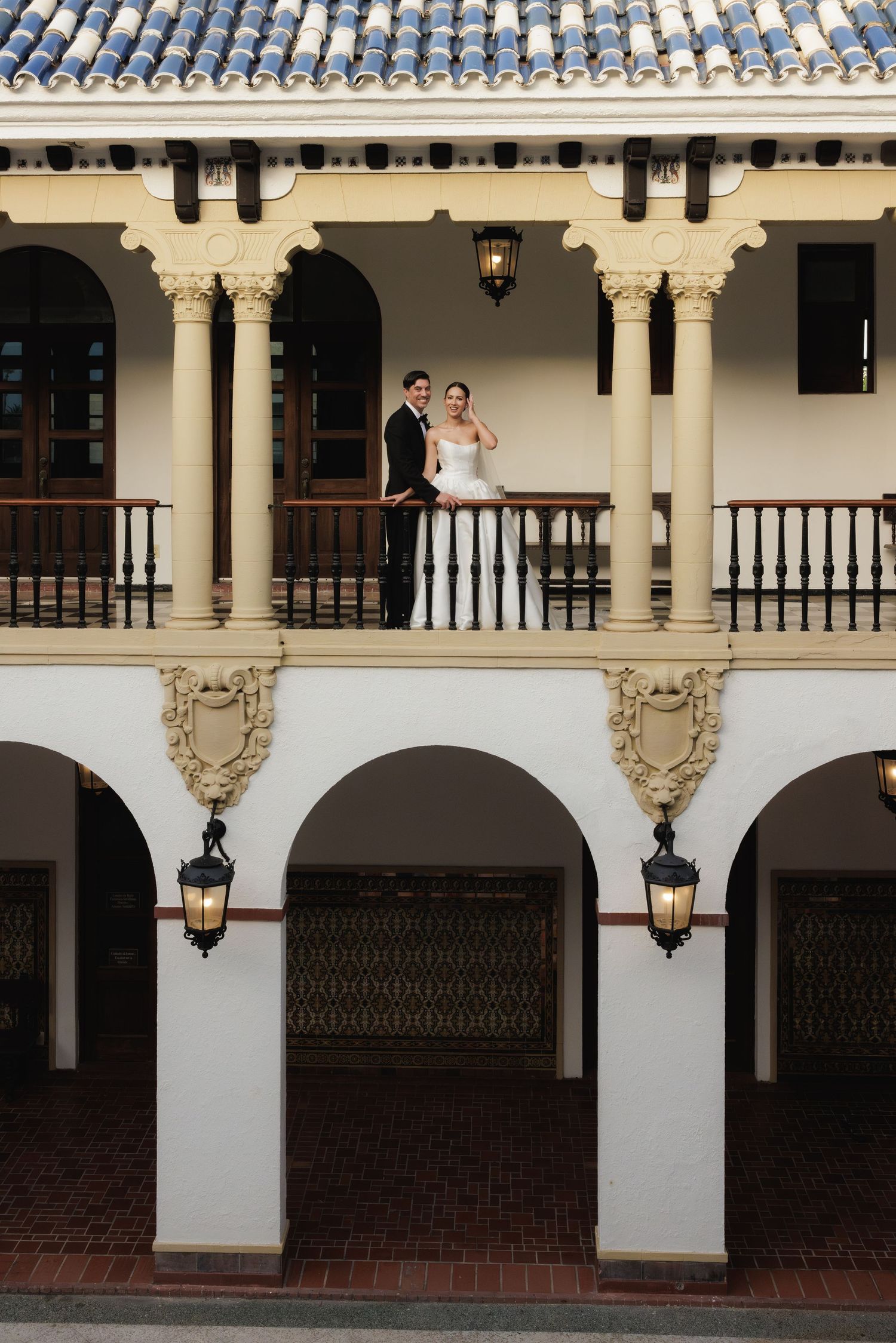 Elegant white Spanish colonial architecture with arches and columns at a wedding venue.