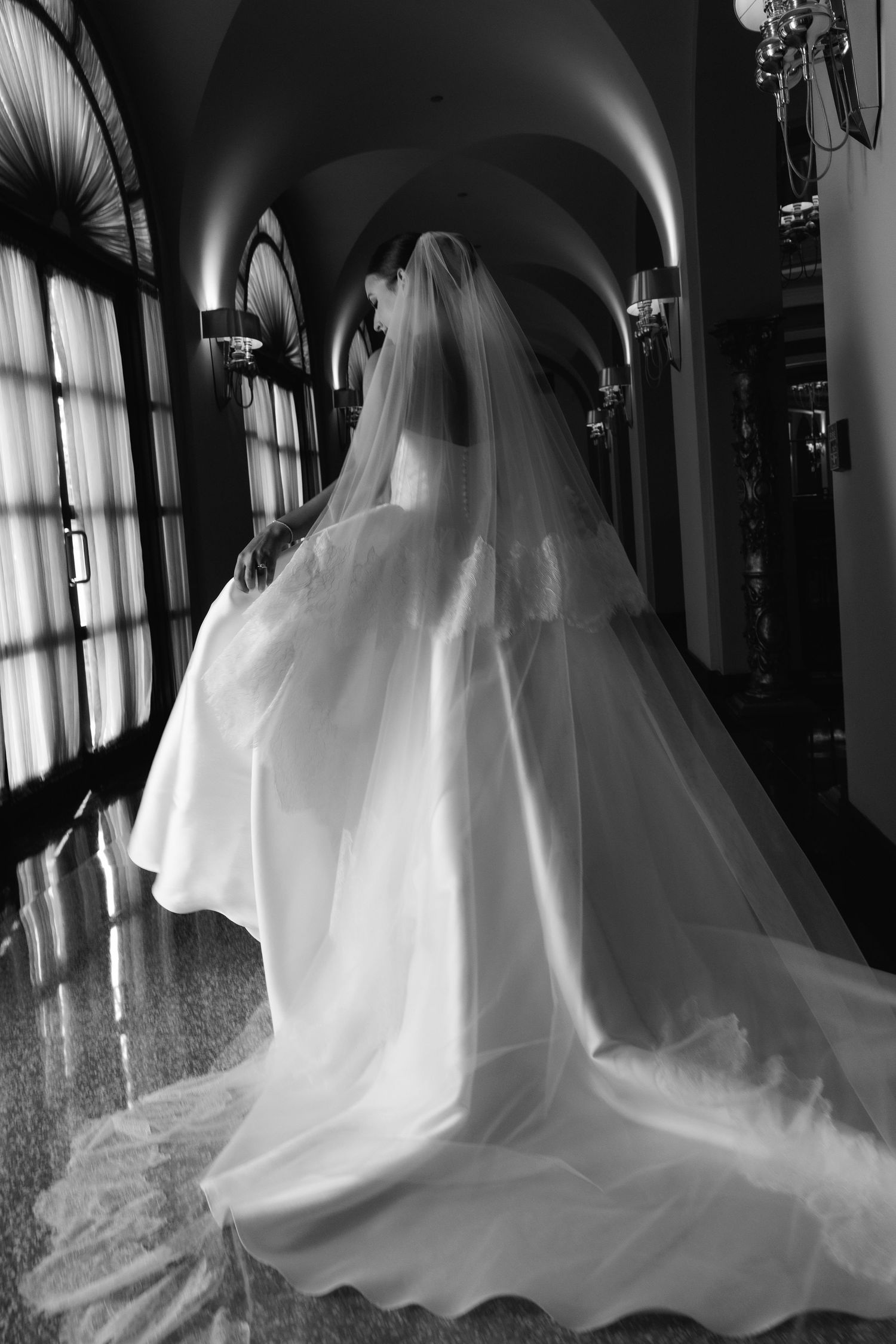 Silhouetted wedding dress shots in a grand hallway with dramatic window lighting.