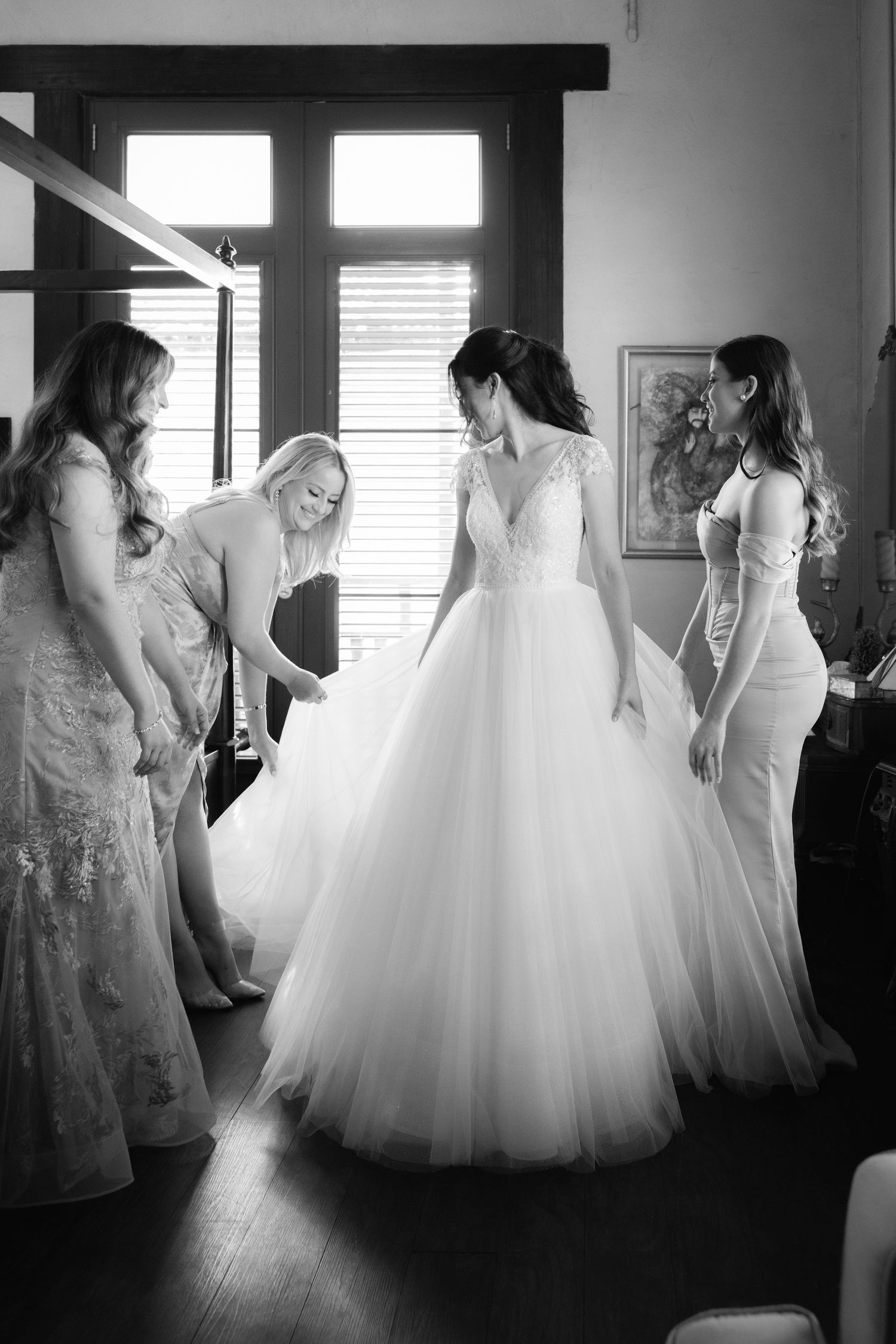 Black and white sequence showing the elegant preparation of a wedding gown.