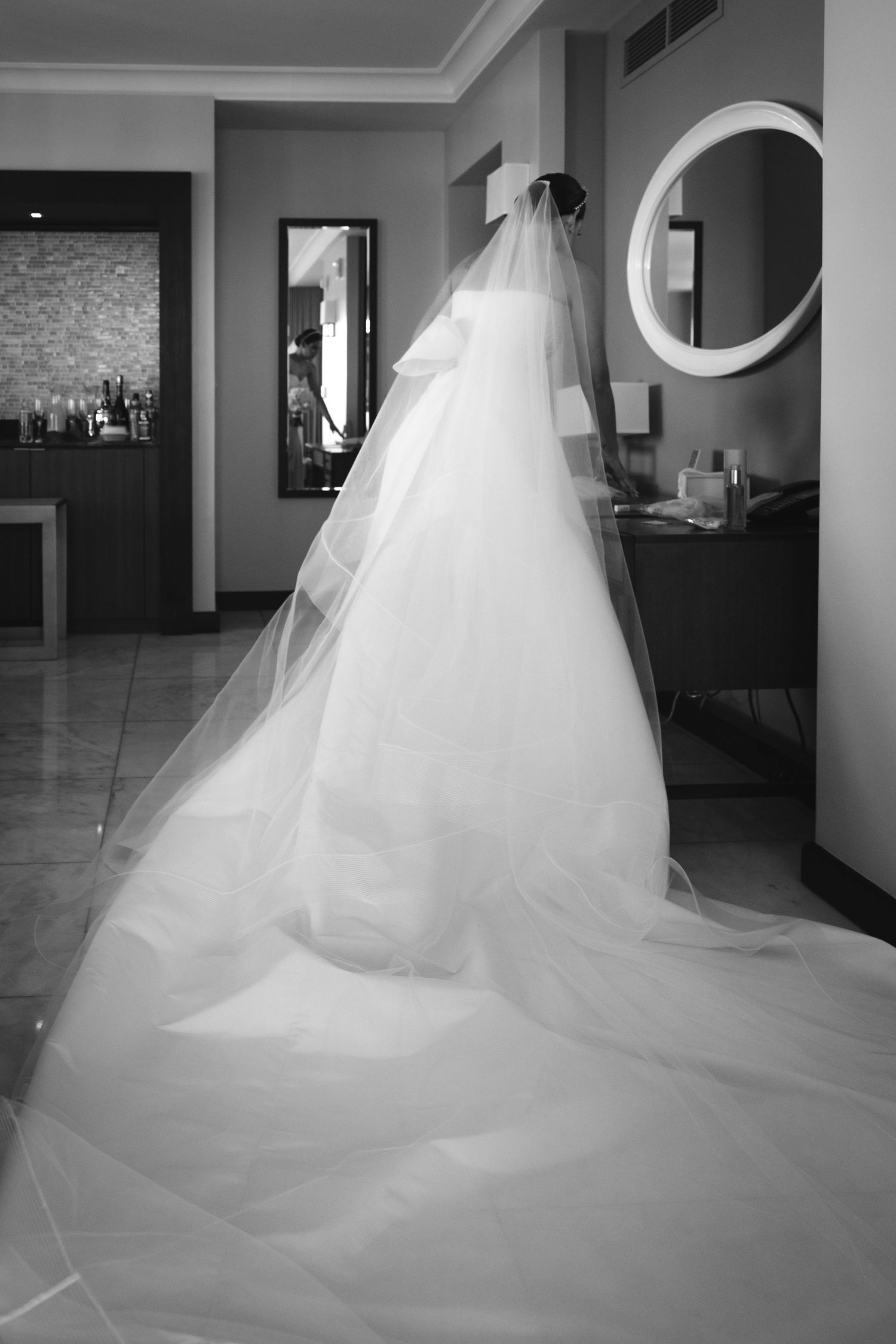 Elegant white wedding dress with flowing tulle train photographed in dramatic black and white sequence.