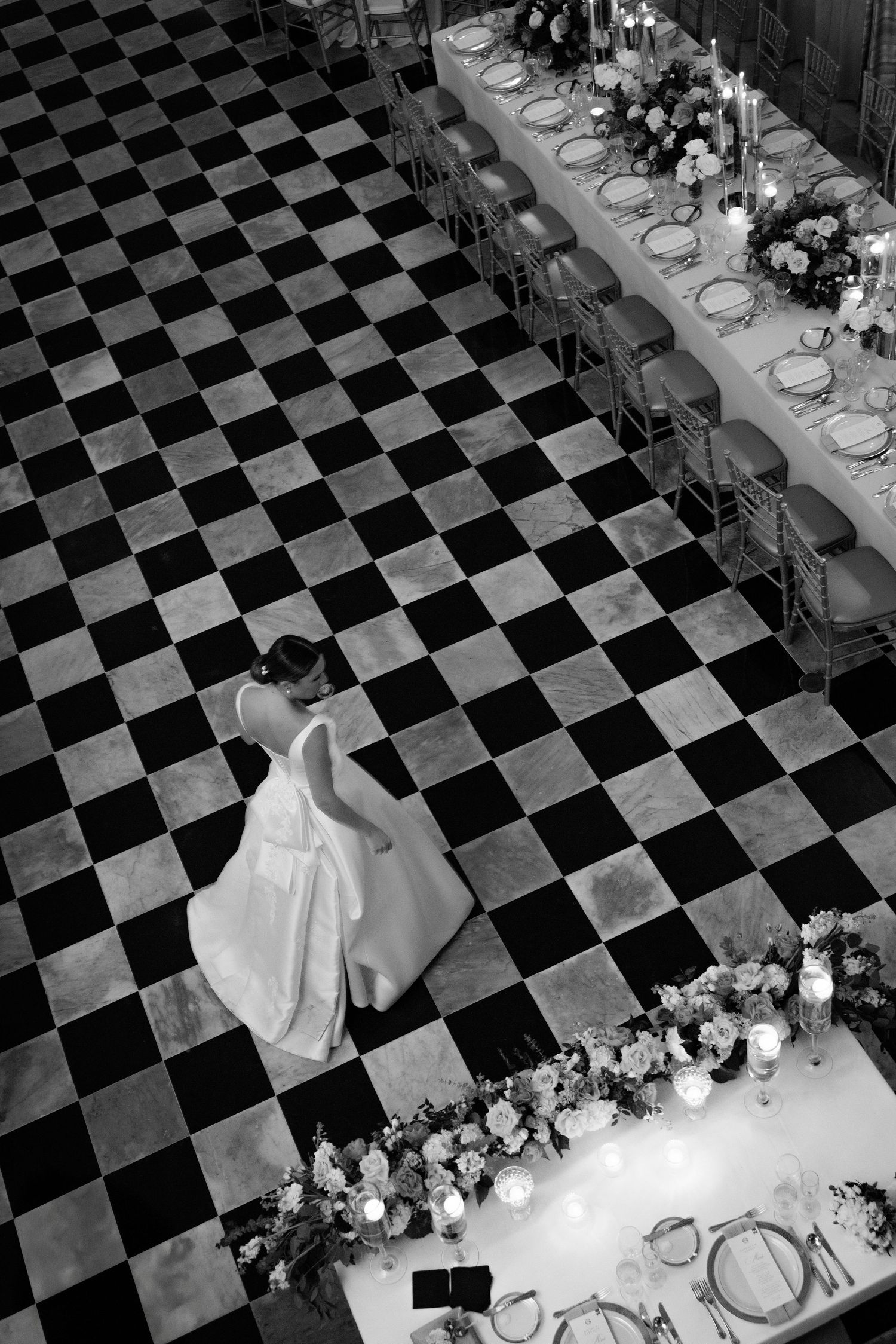 Overhead view of a formal event setup with black and white checkered floor and elegant table settings.