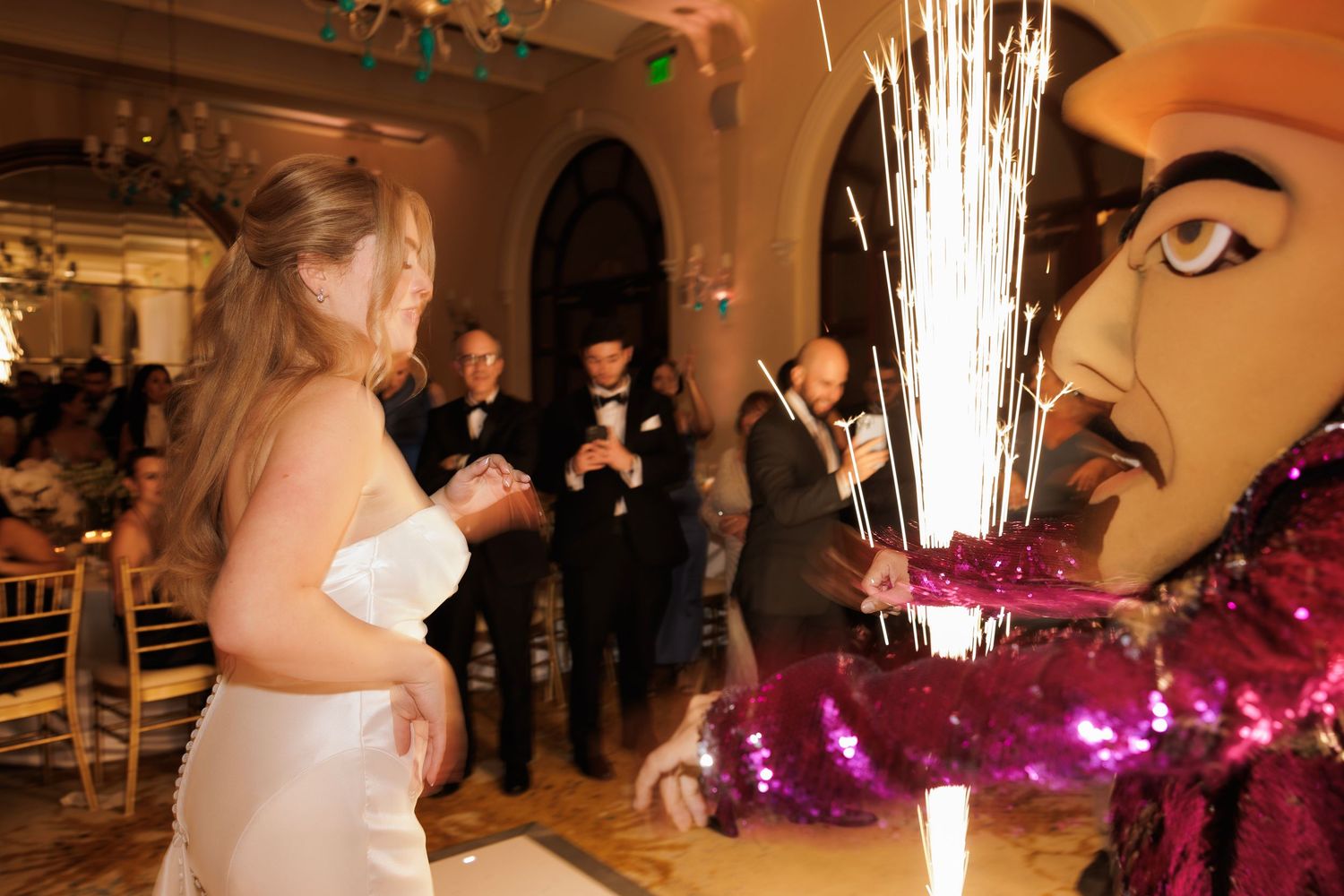 Couples dancing and celebrating at an elegant wedding reception with purple lighting and floral decorations.