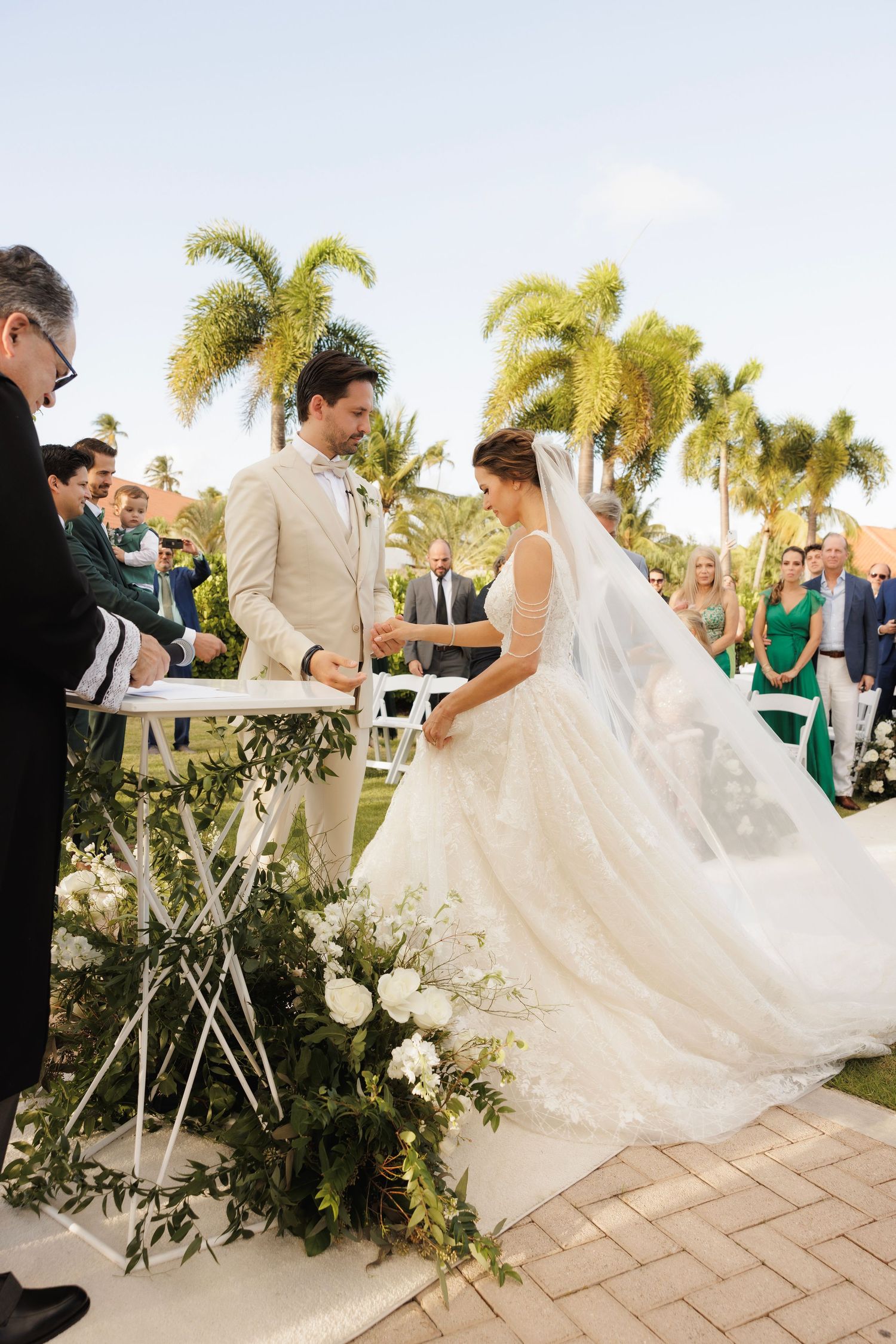 A romantic outdoor wedding ceremony by palm trees with the couple dancing and celebrating in a sequence of photos.