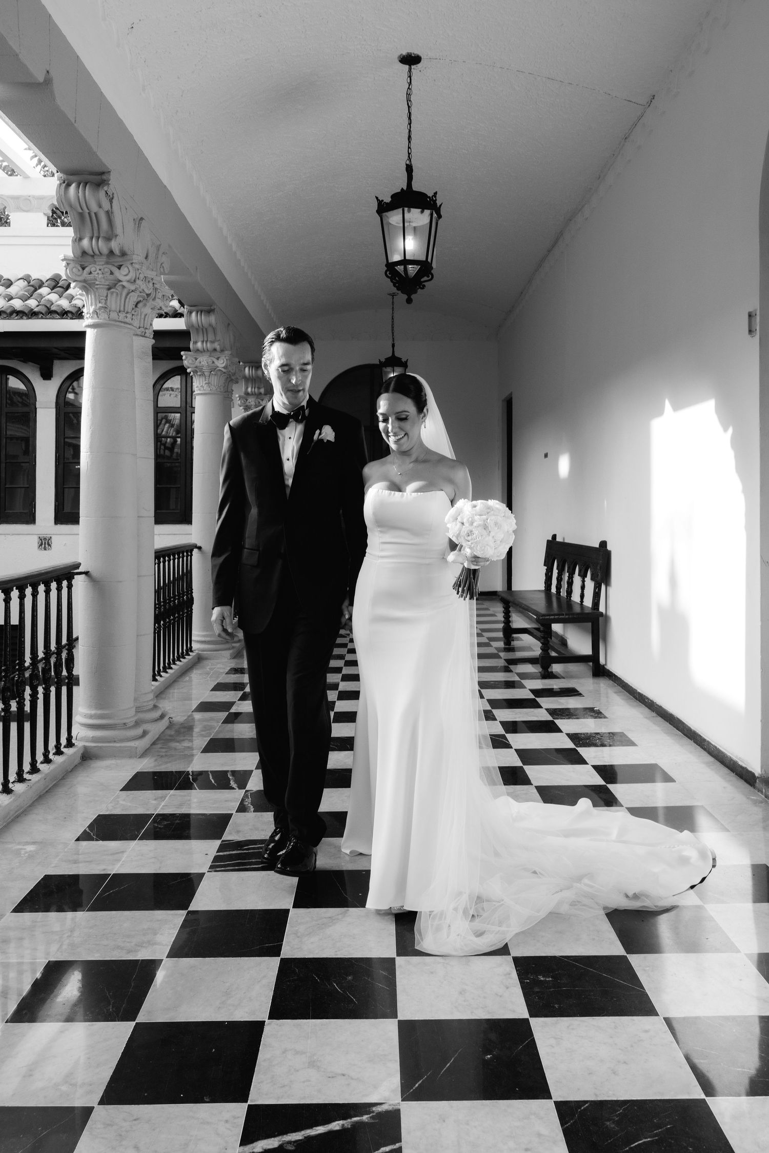 Black and white wedding photography sequence showing couple in elegant hallway with checkered floor.