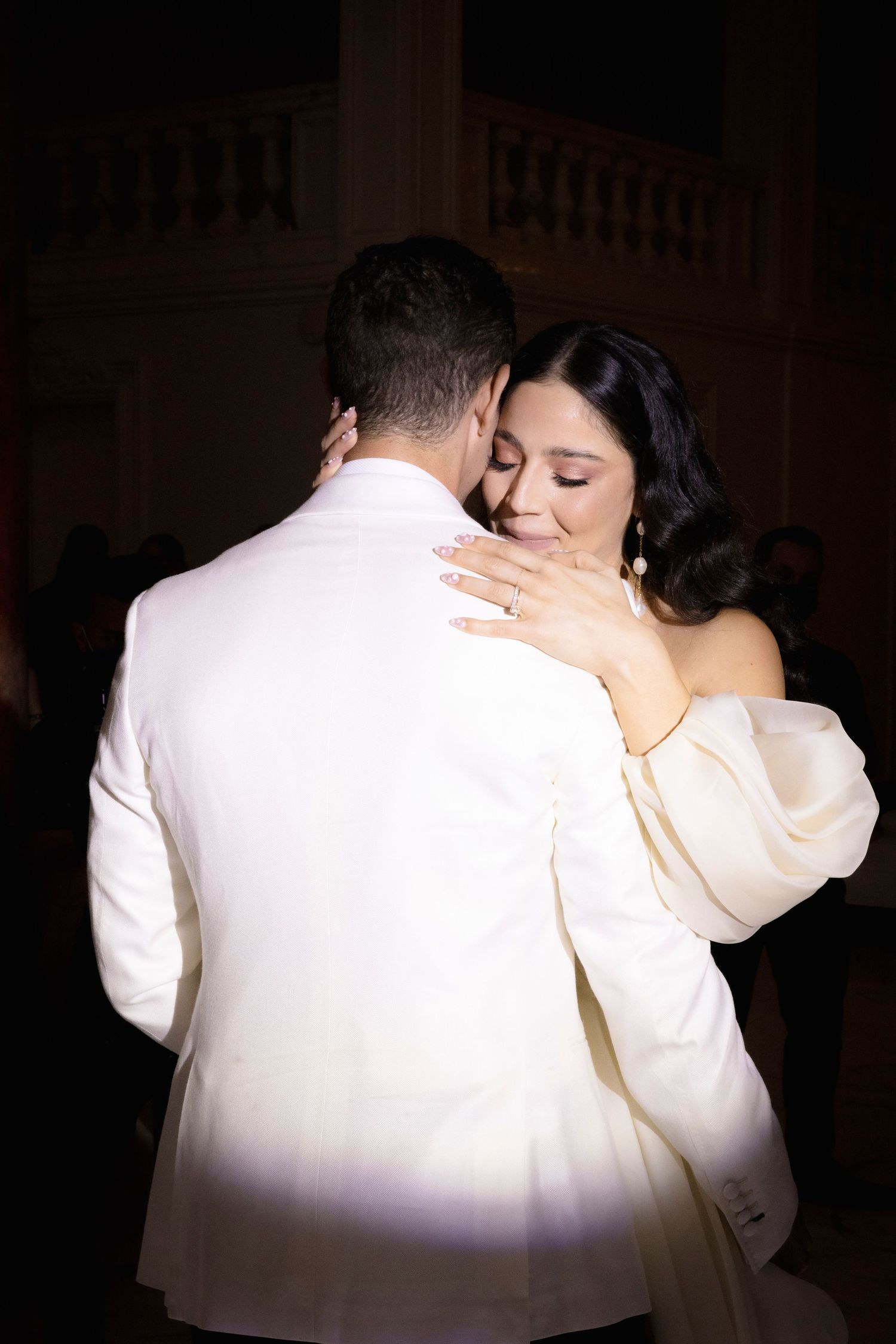 Intimate dance moment captured in dramatic lighting during a wedding reception.