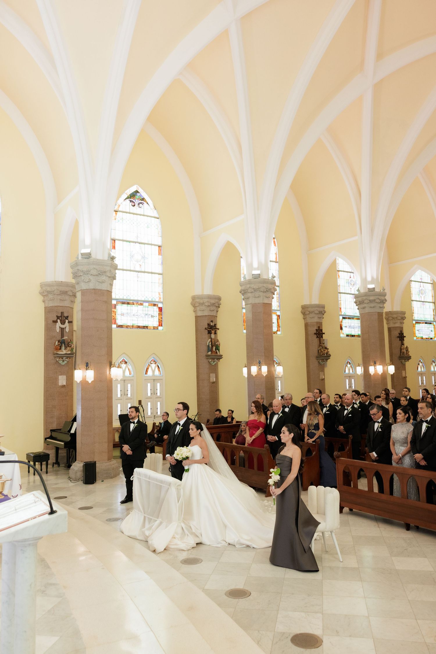 Wedding celebration in ornate church with vaulted ceilings and cream walls.