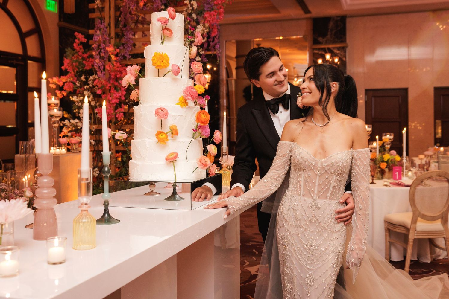 Elegant wedding reception ballroom decorated with floral arrangements and romantic lighting for an evening celebration.