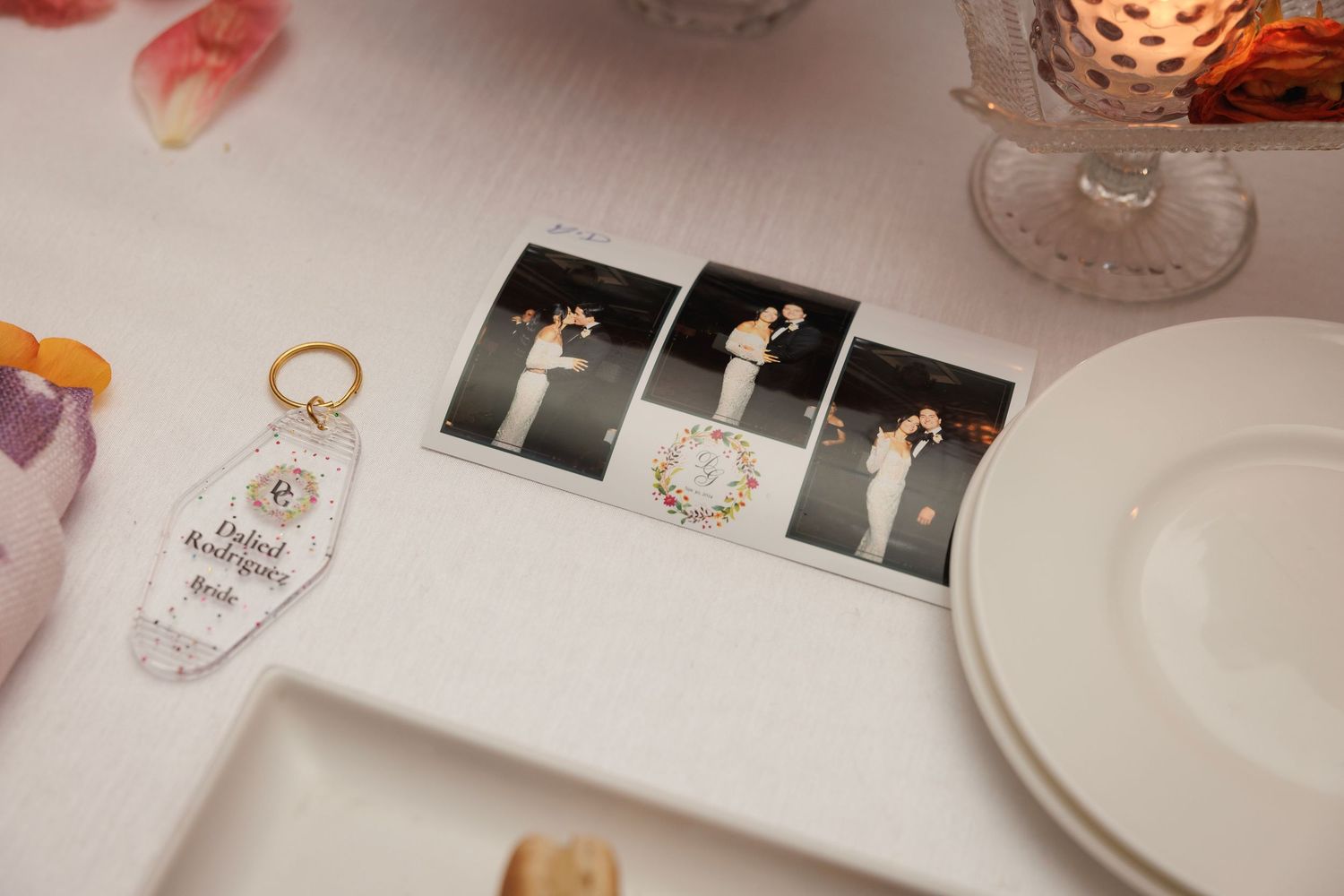 Wedding photos and decorative items displayed on a white table setting with candlelight accents.