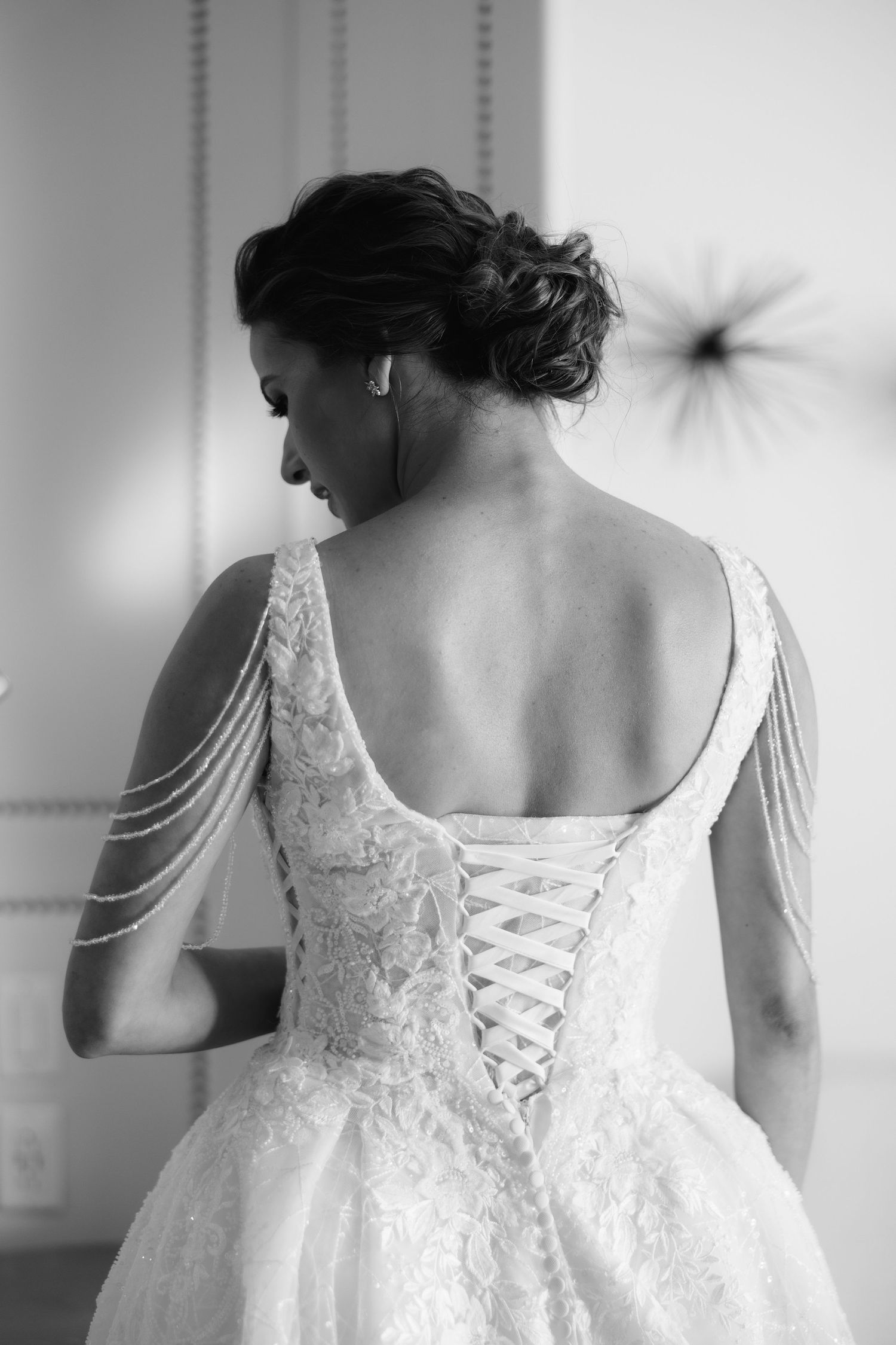 Black and white photos of wedding dress details showing intricate lace and corset back lacing details.