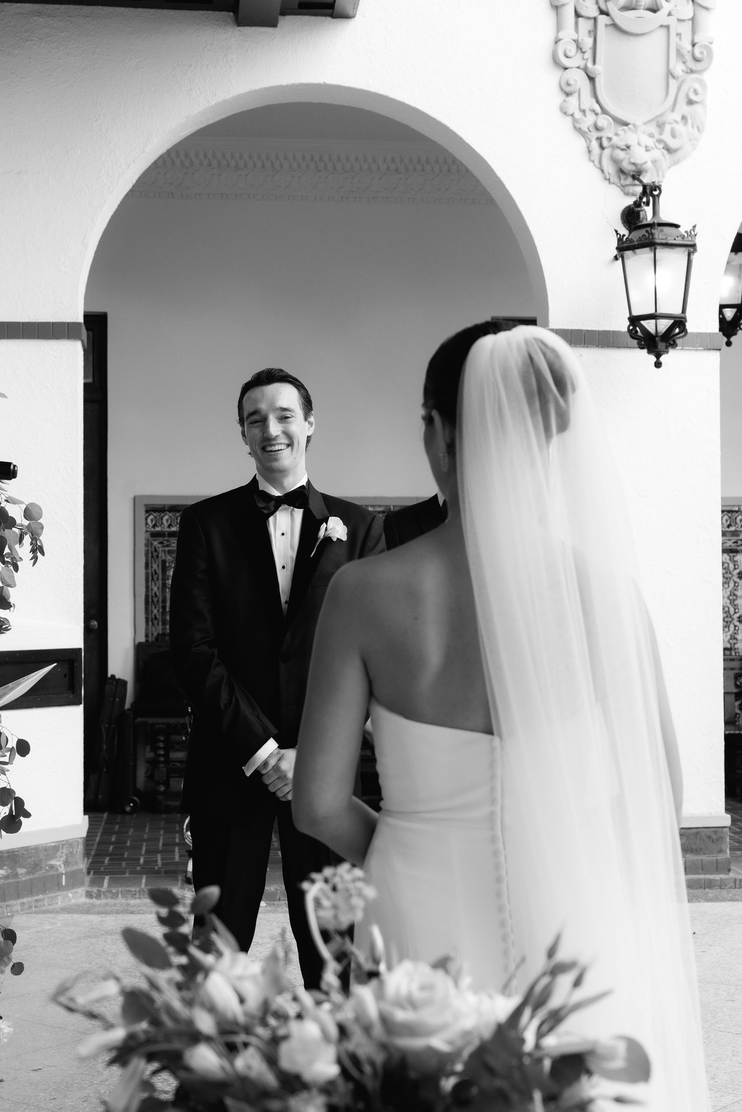 Black and white candid wedding photos showcase couples in formal attire under arched hallway.