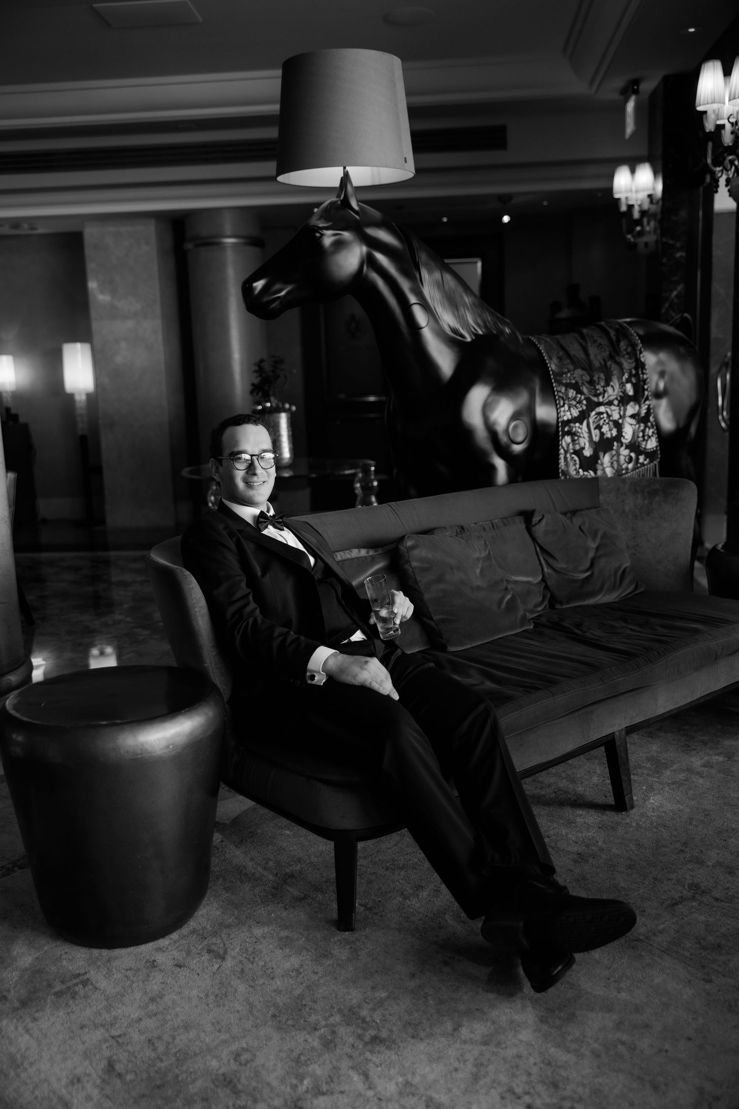 A sequence of black and white photos showing playful groomsmen jumping and posing in formal attire.