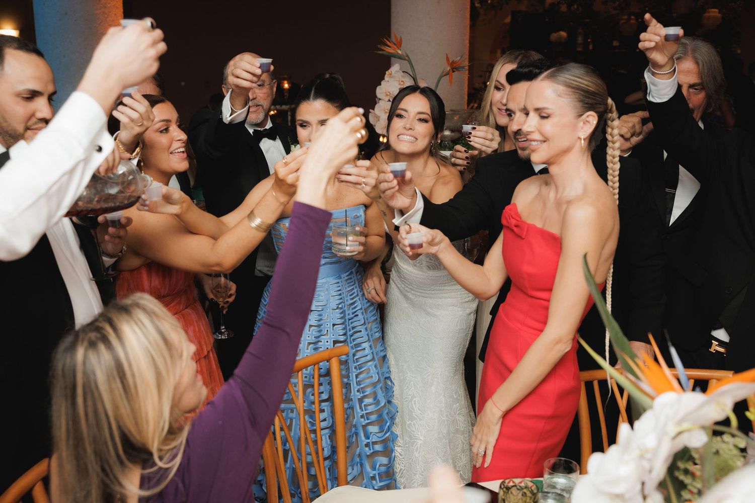 Wedding party dancing and celebrating on a lively dance floor during an evening reception.