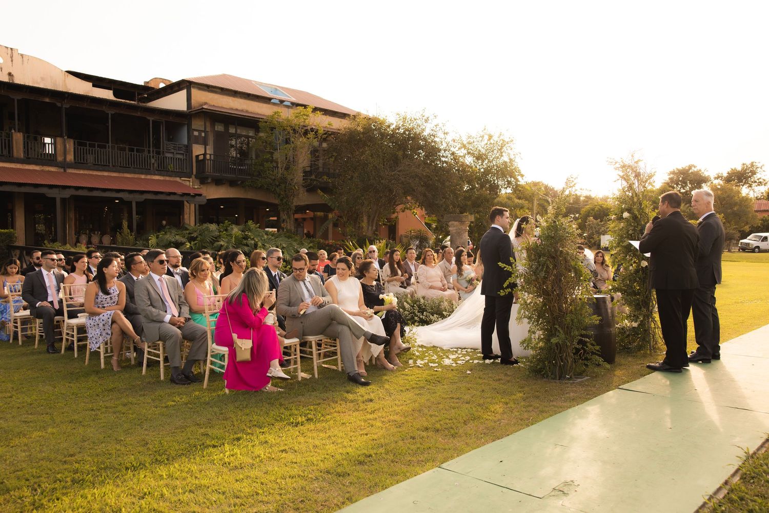 Outdoor wedding ceremony seating arrangement with golden sunset lighting.