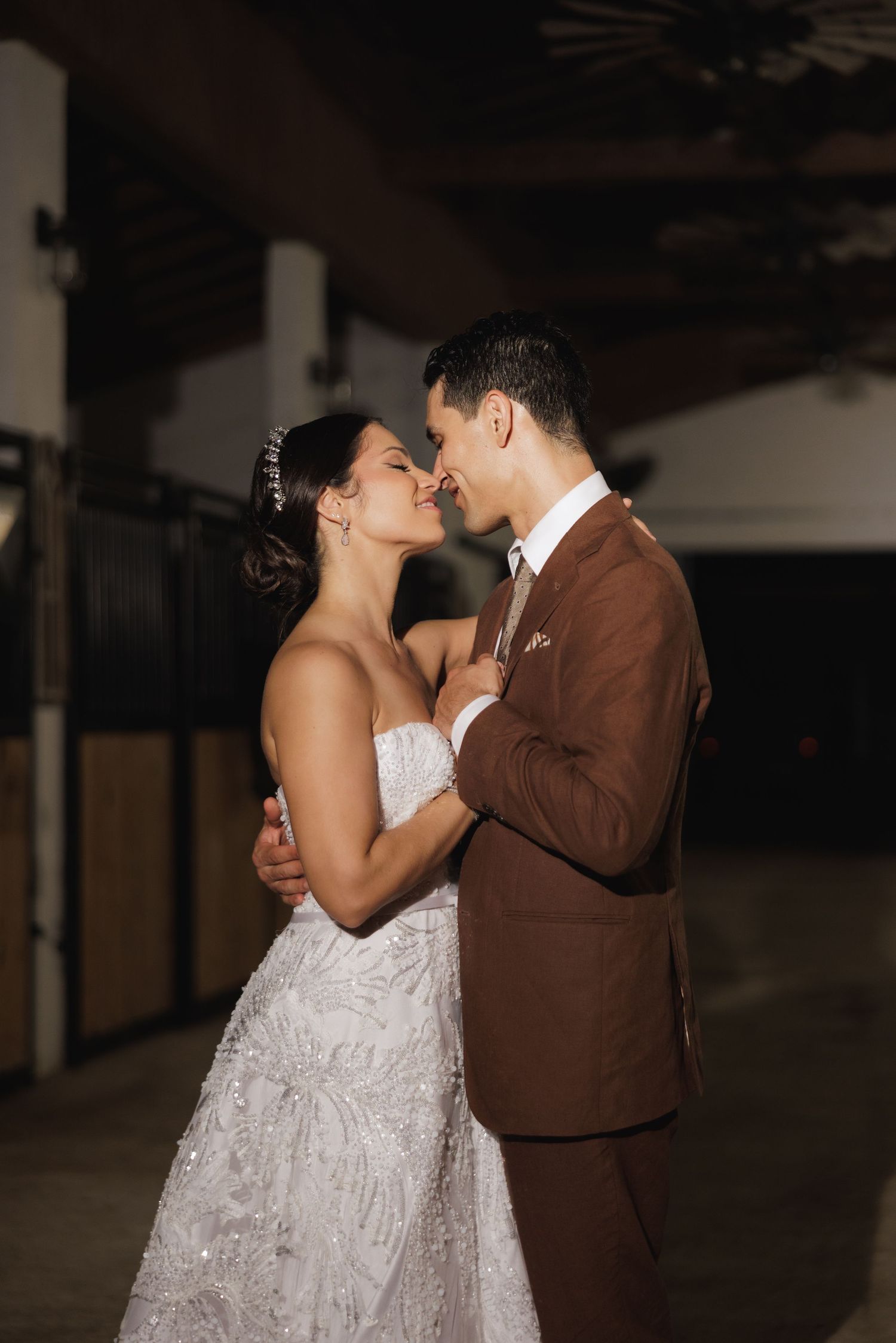 A couple shares an intimate dance moment in formal wedding attire.