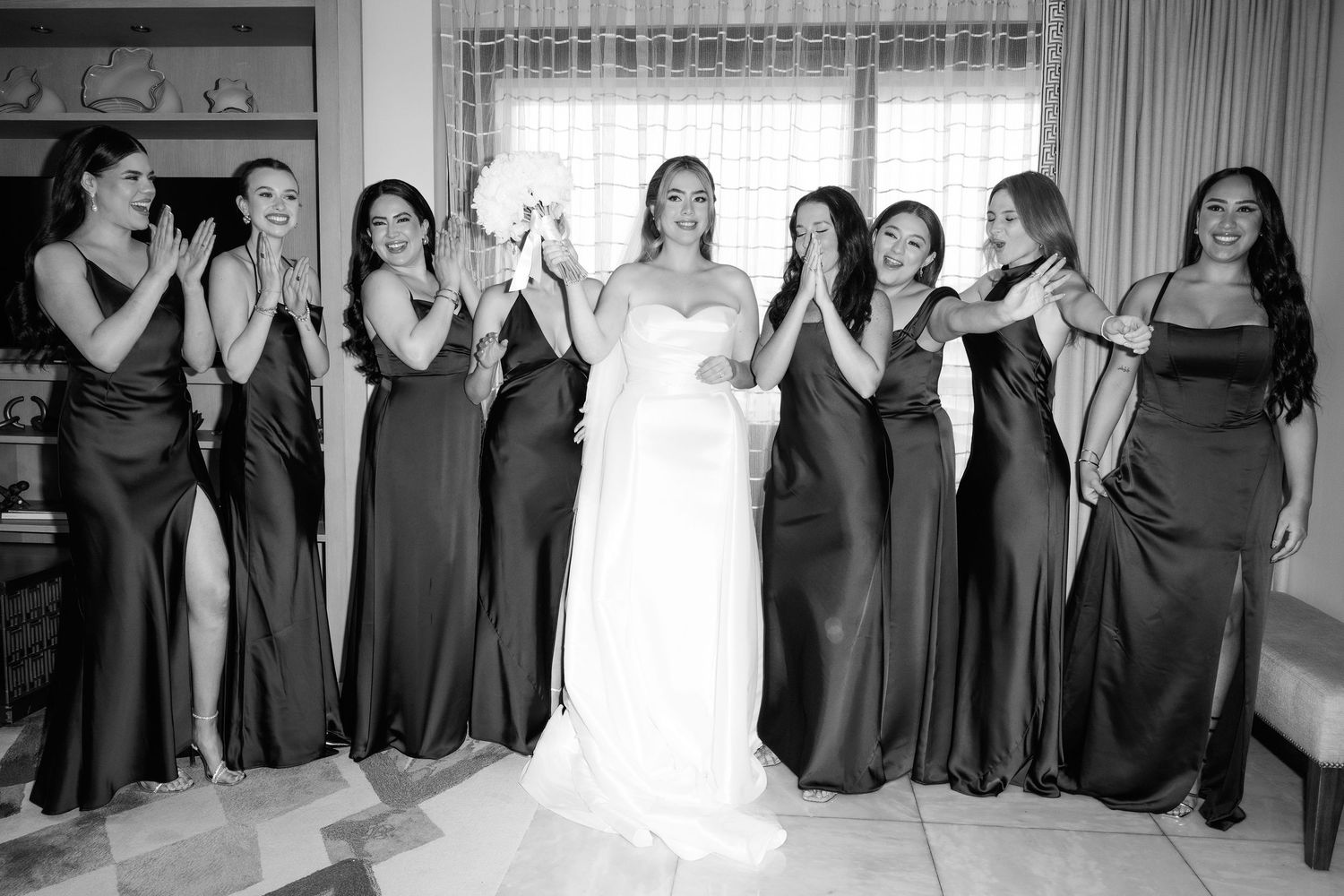 Wedding party lined up wearing coordinated black dresses and formal attire.