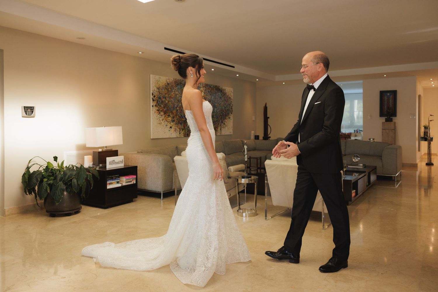 Wedding preparations in a spacious modern room with elegant decor and marble flooring.