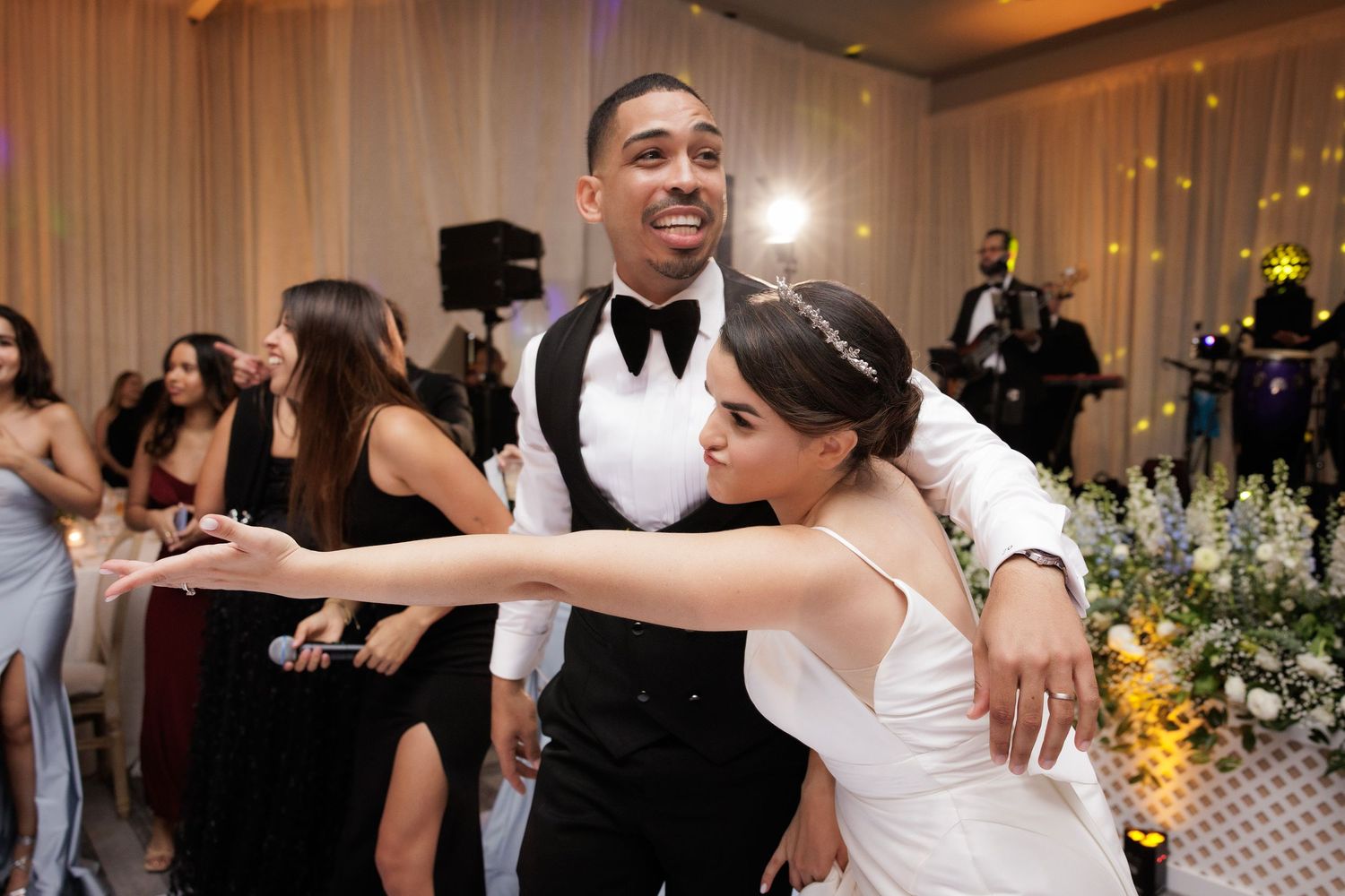 Wedding guests celebrating and dancing together on a crowded ballroom dance floor at an elegant reception.